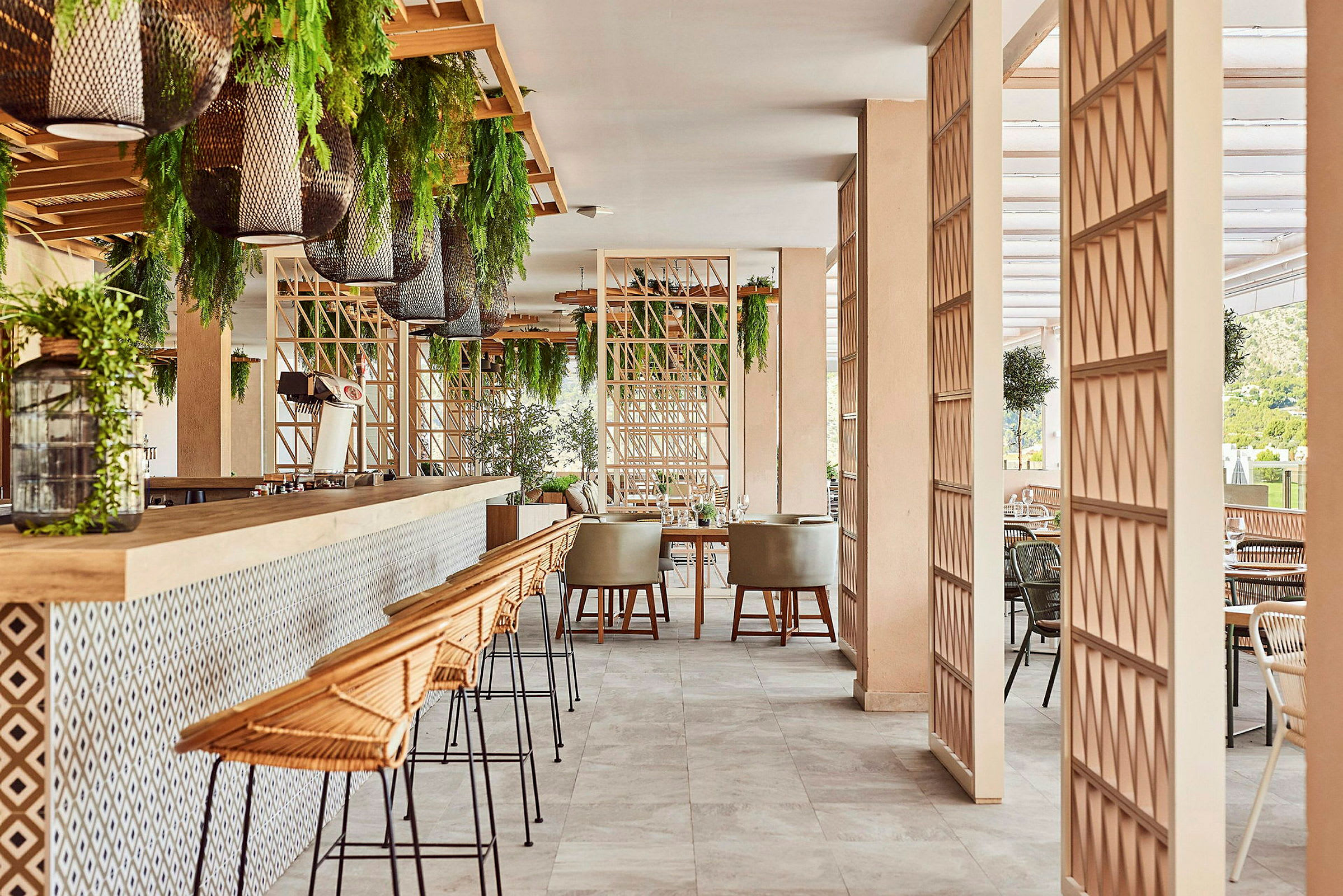 Et moderne restaurationsmiljø med barstole, borde og grønne planter. (AI-genereret tekst)