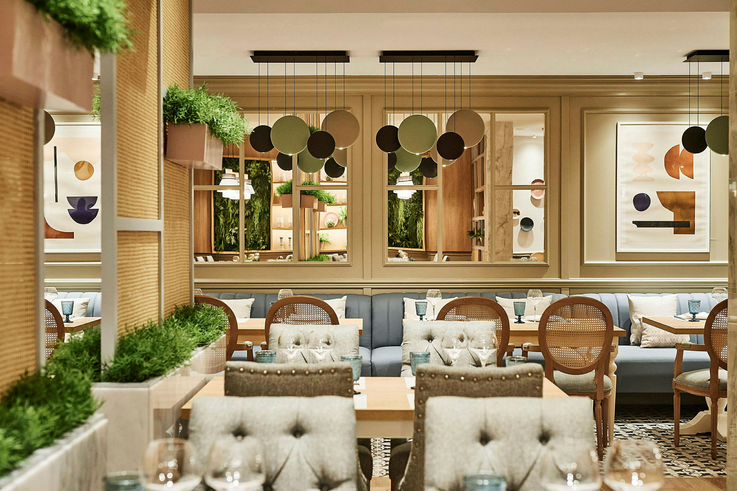 Interiør af en restaurant med stole, borde og planter. (AI-genereret tekst)