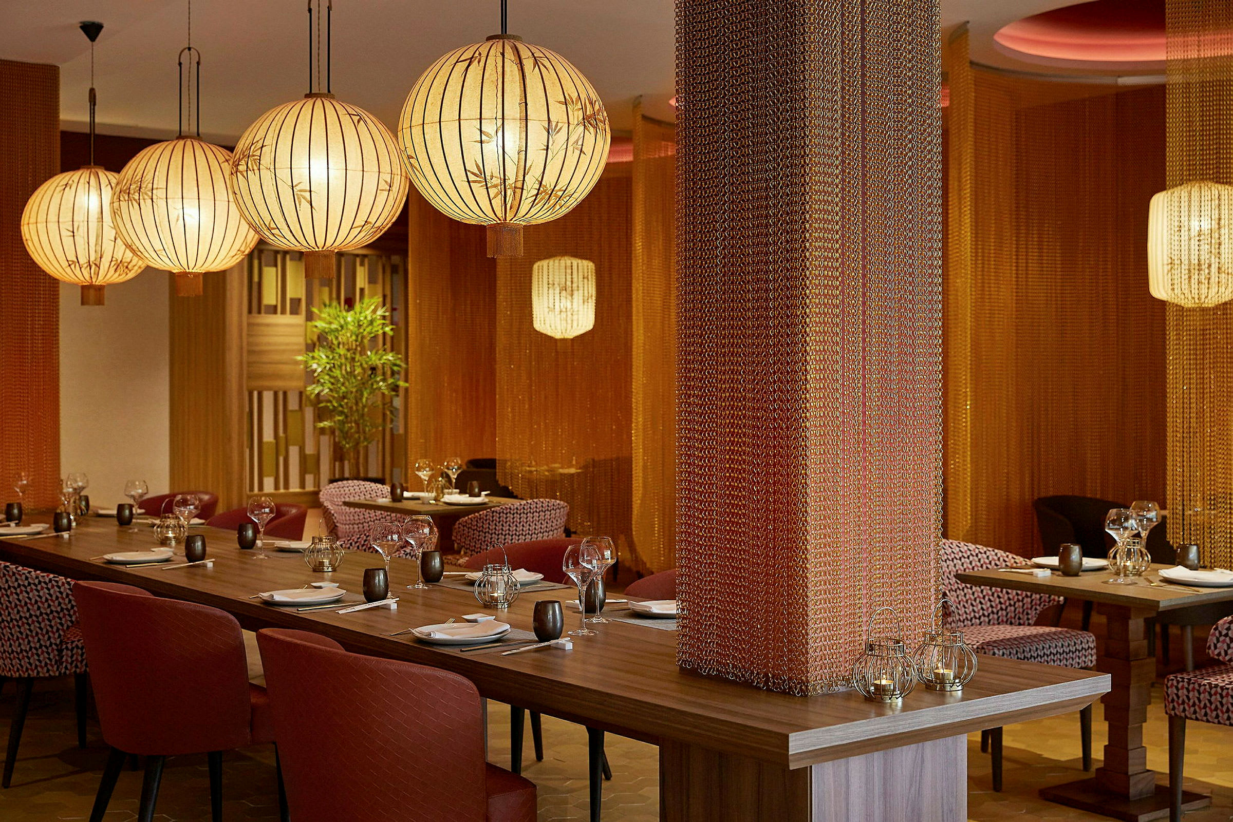 Restaurantinteriør med elegant belysning og dækkede borde. (AI-genereret tekst)