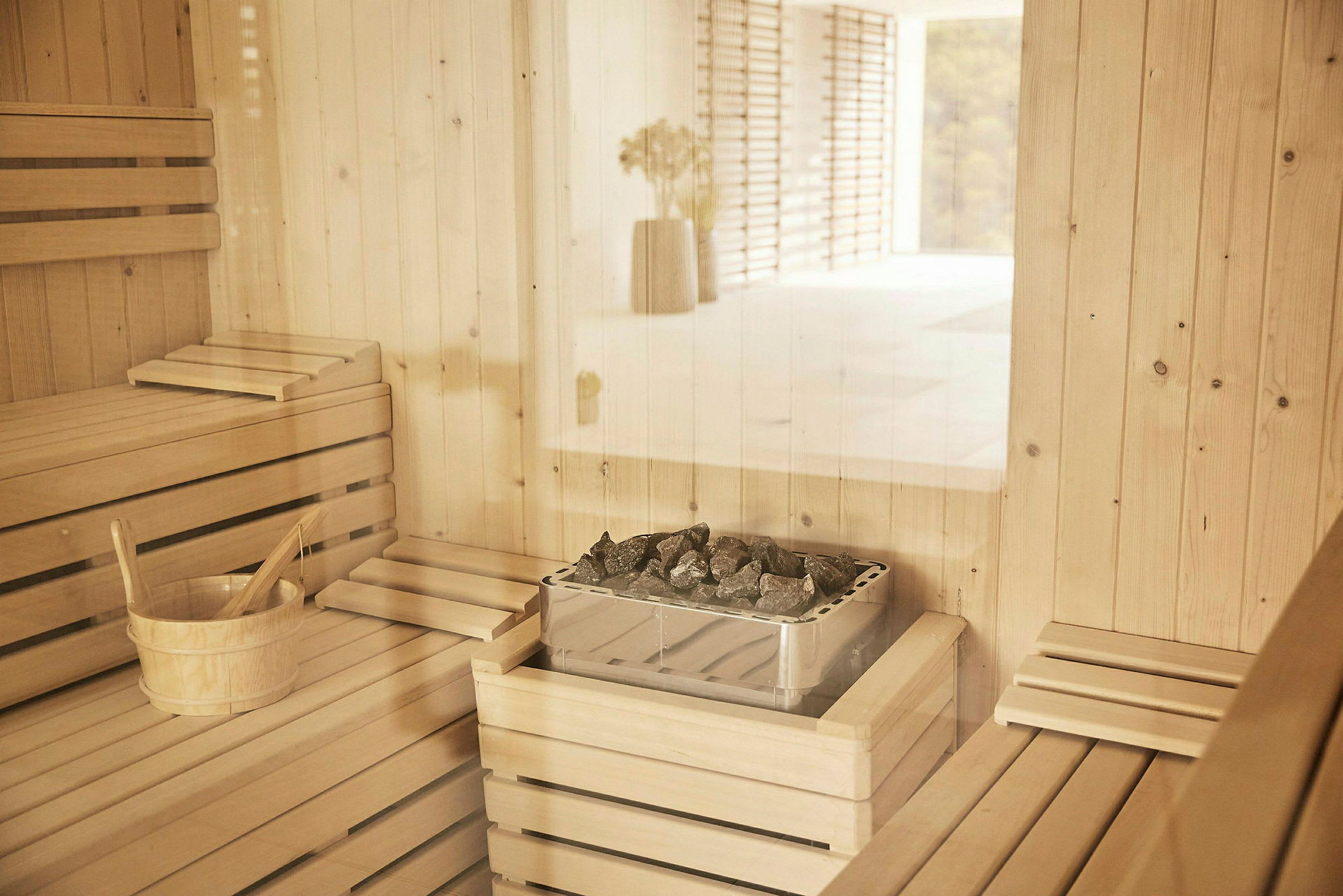 En sauna med træbænke og en saunaovn med sten. (AI-genereret tekst)