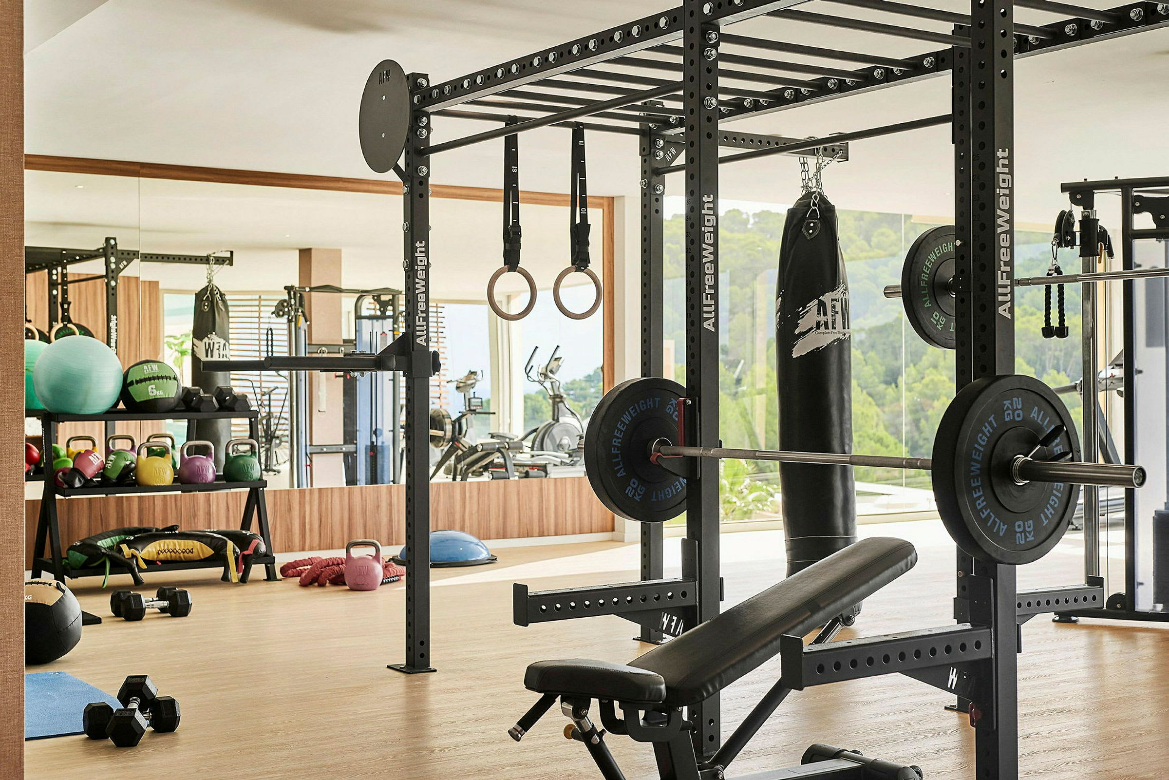 Et fitnesscenter med træningsudstyr, herunder vægte, kettlebells, ringe og en boksebold. (AI-genereret tekst)