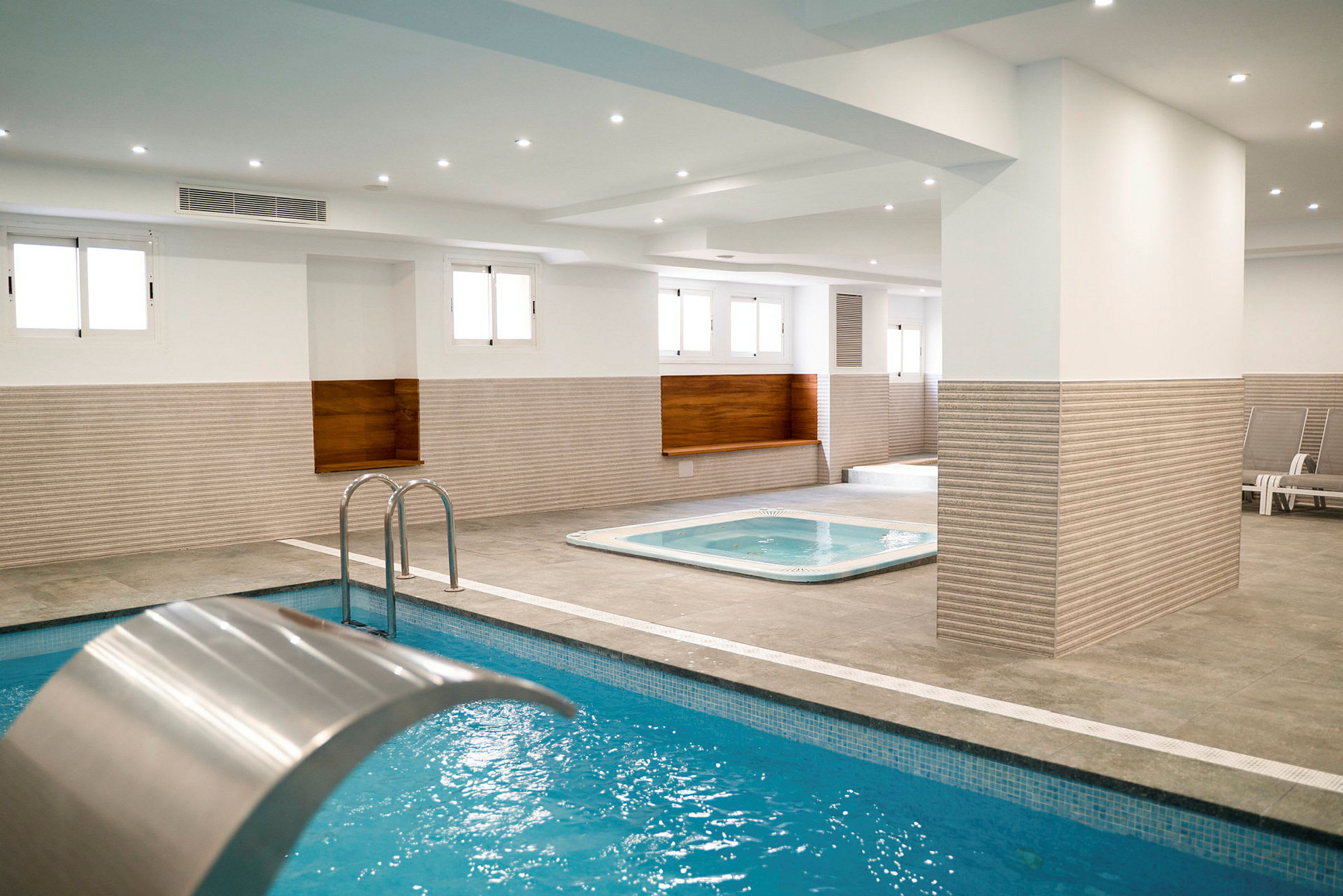Indendørs spa med pool og boblebad. (AI-genereret tekst)
