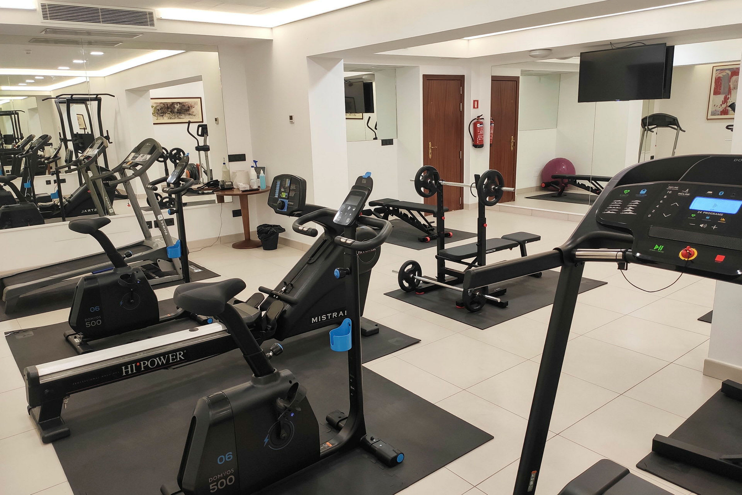 Billede af et fitnesscenter med moderne træningsapparater, herunder løbebånd, motionscykler og styrketræningsudstyr. (AI-genereret tekst)