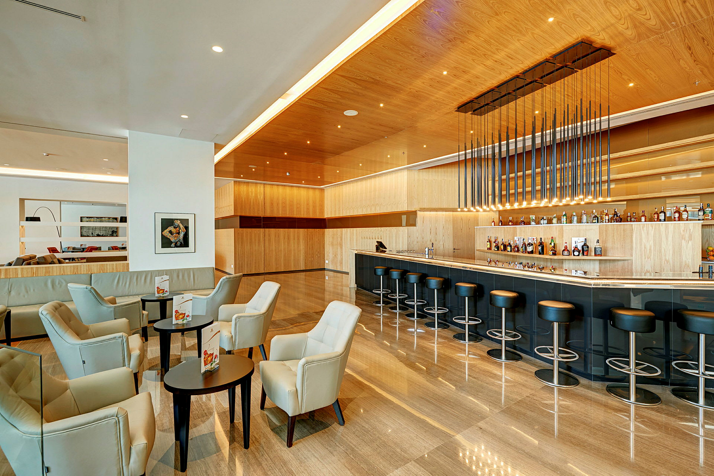 Moderne hotelbar med siddegrupper og høje stole ved bardisken. (AI-genereret tekst)
