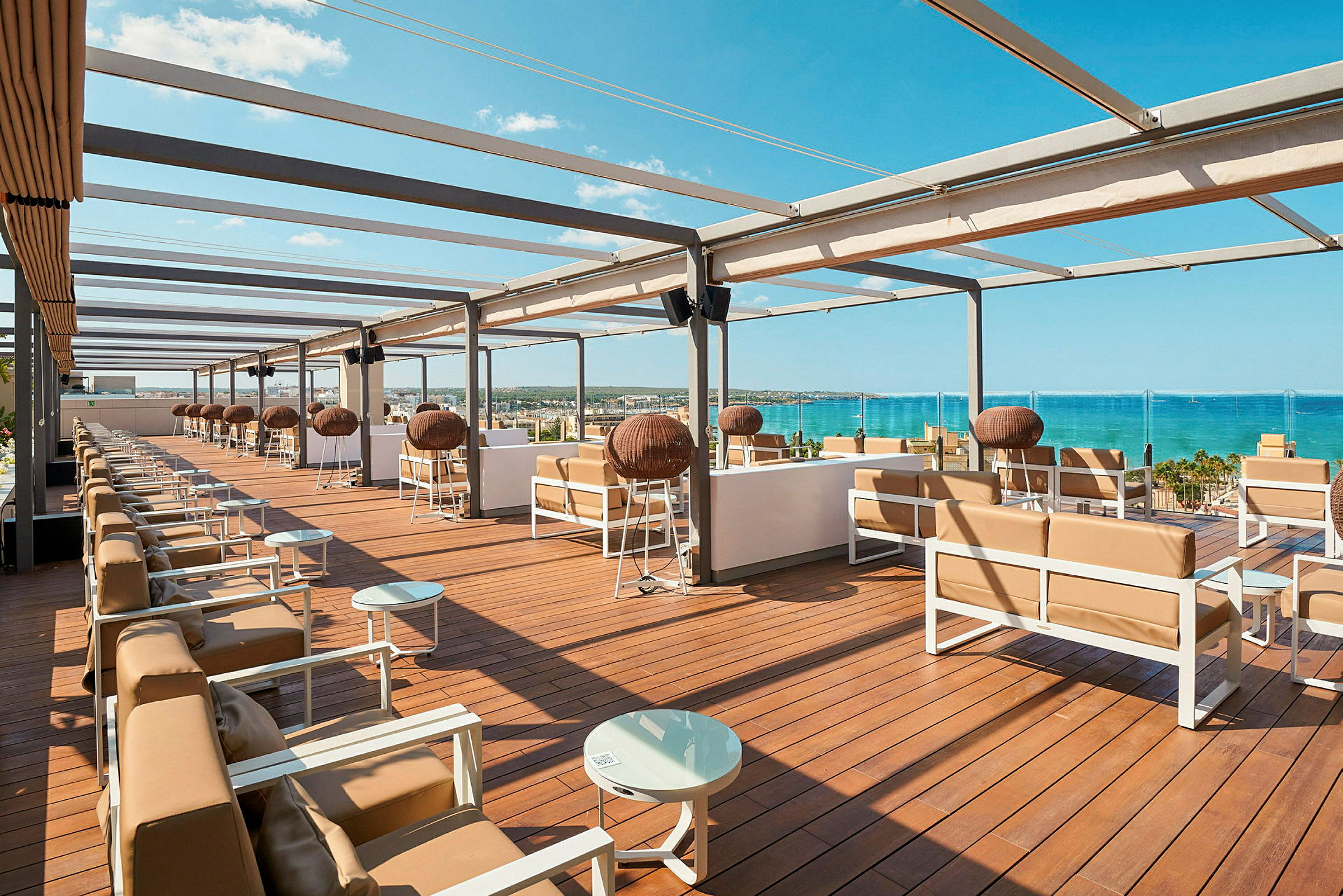 En tagterrasse med siddegrupper og udsigt over havet. (AI-genereret tekst)
