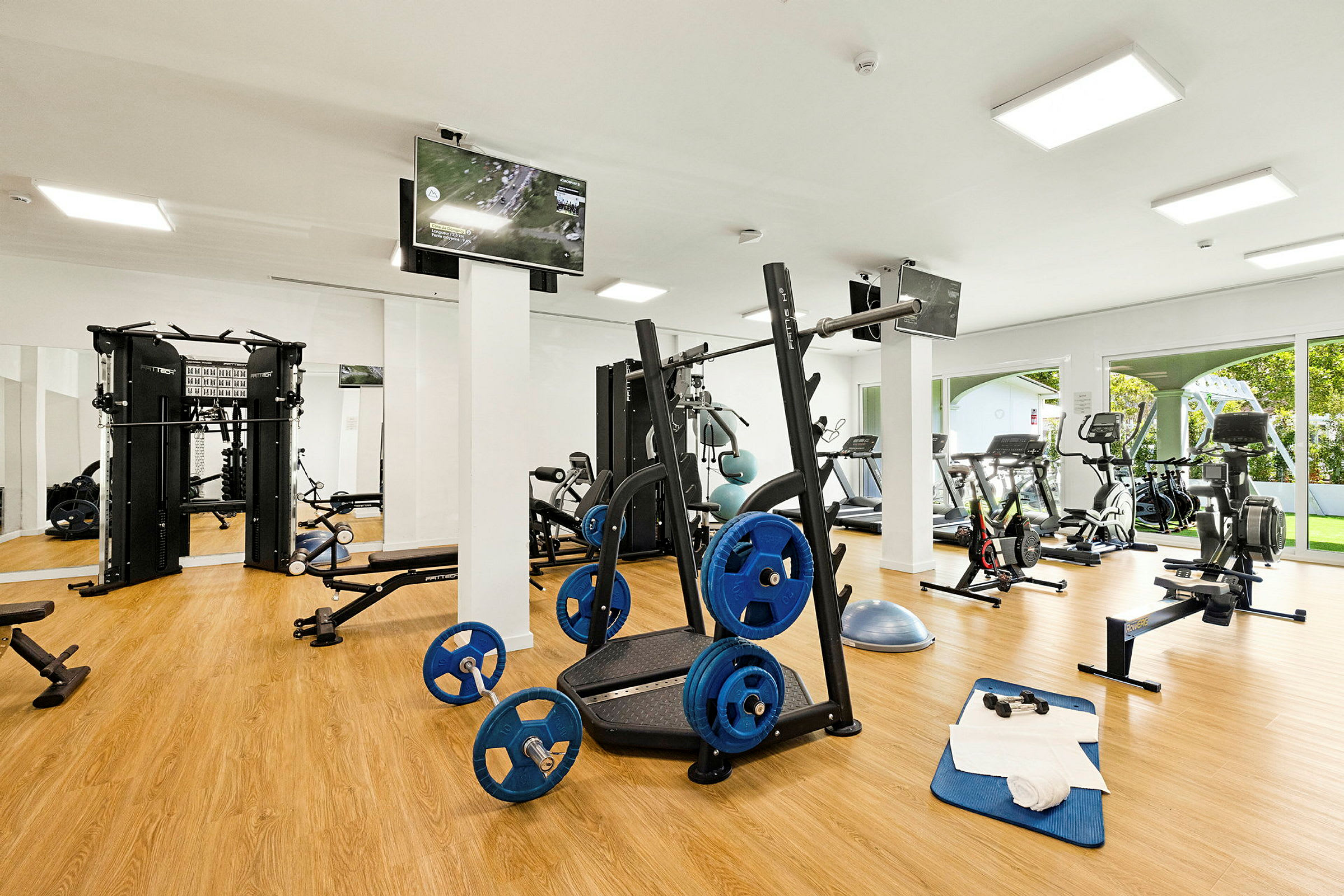 Et fitnesscenter med træningsudstyr såsom løbebånd, cykler og vægtstativer. (AI-genereret tekst)