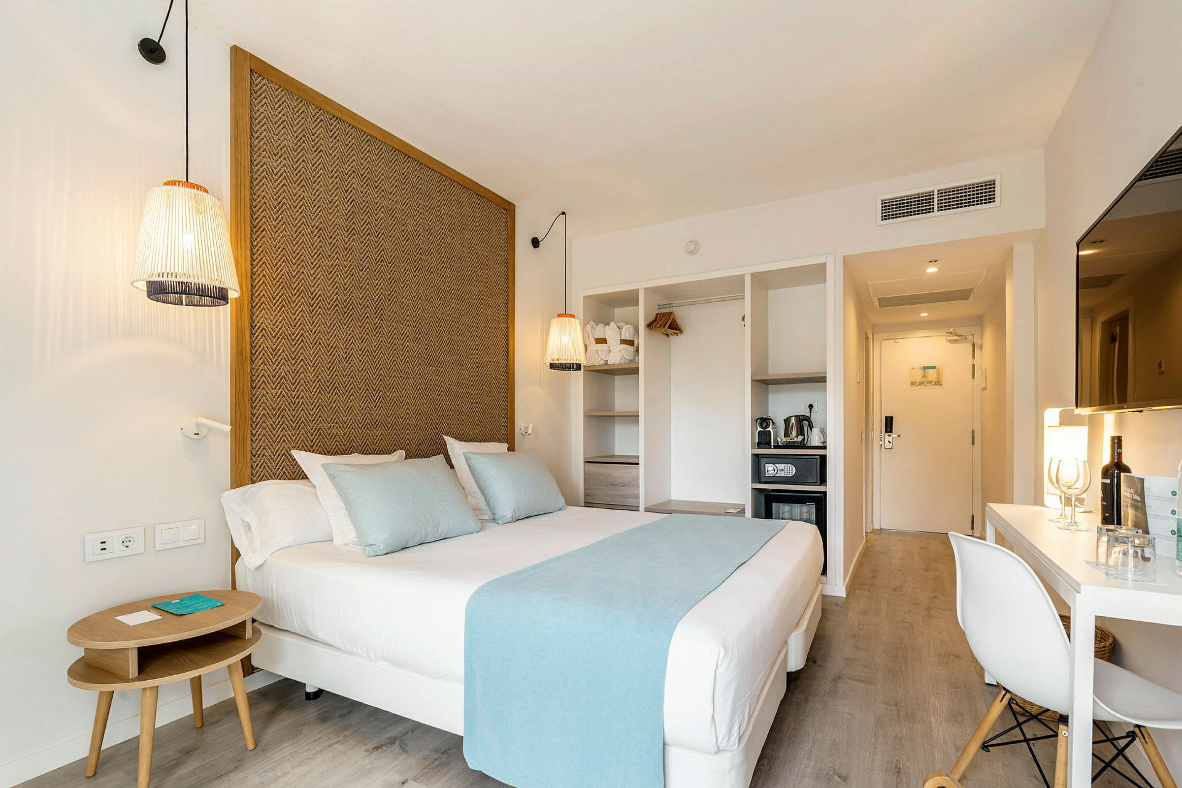 Hotelværelse med seng, siddepladser, tv og minibar. (AI-genereret tekst)
