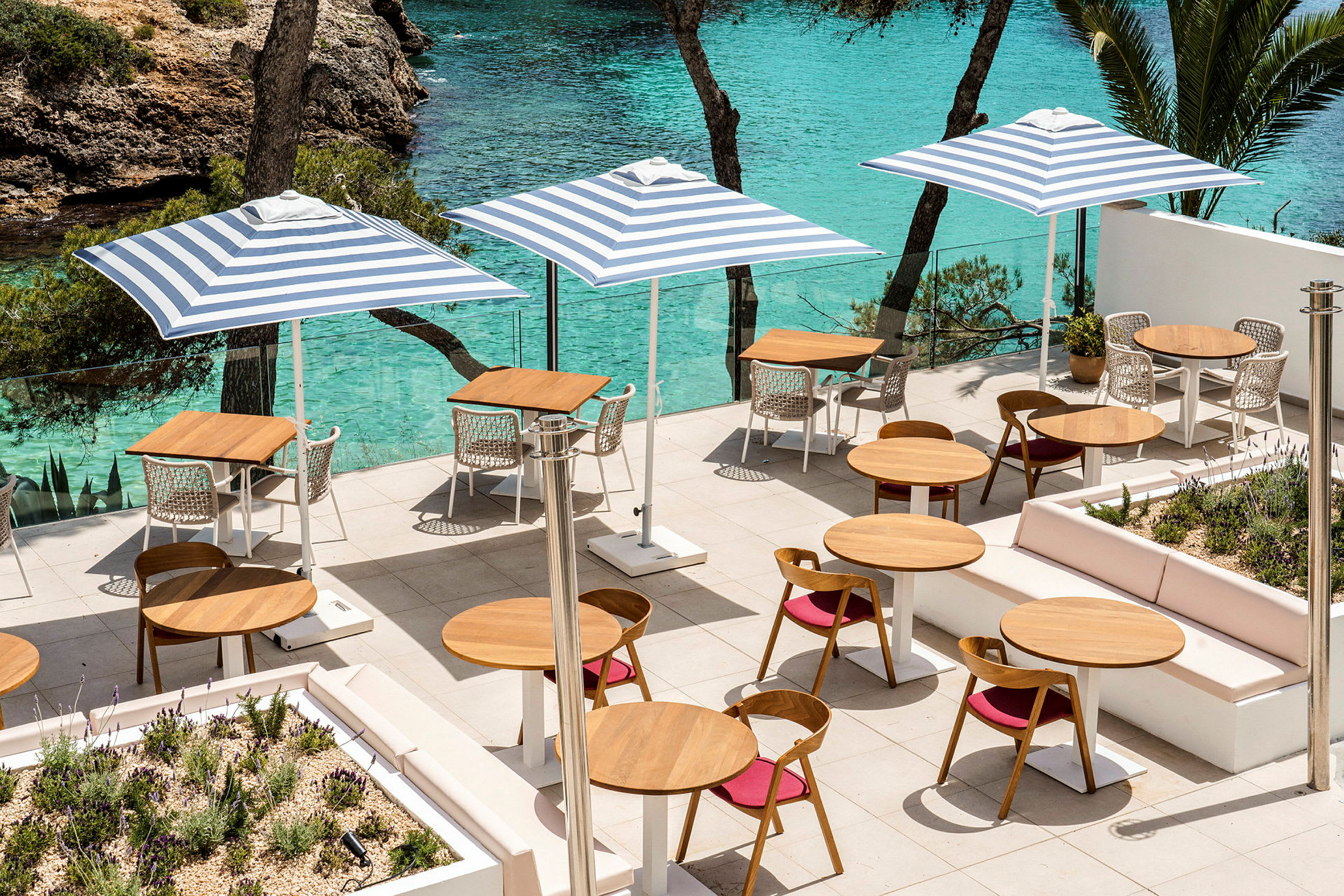 Terrasse med borde og stole samt havudsigt. (AI-genereret tekst)