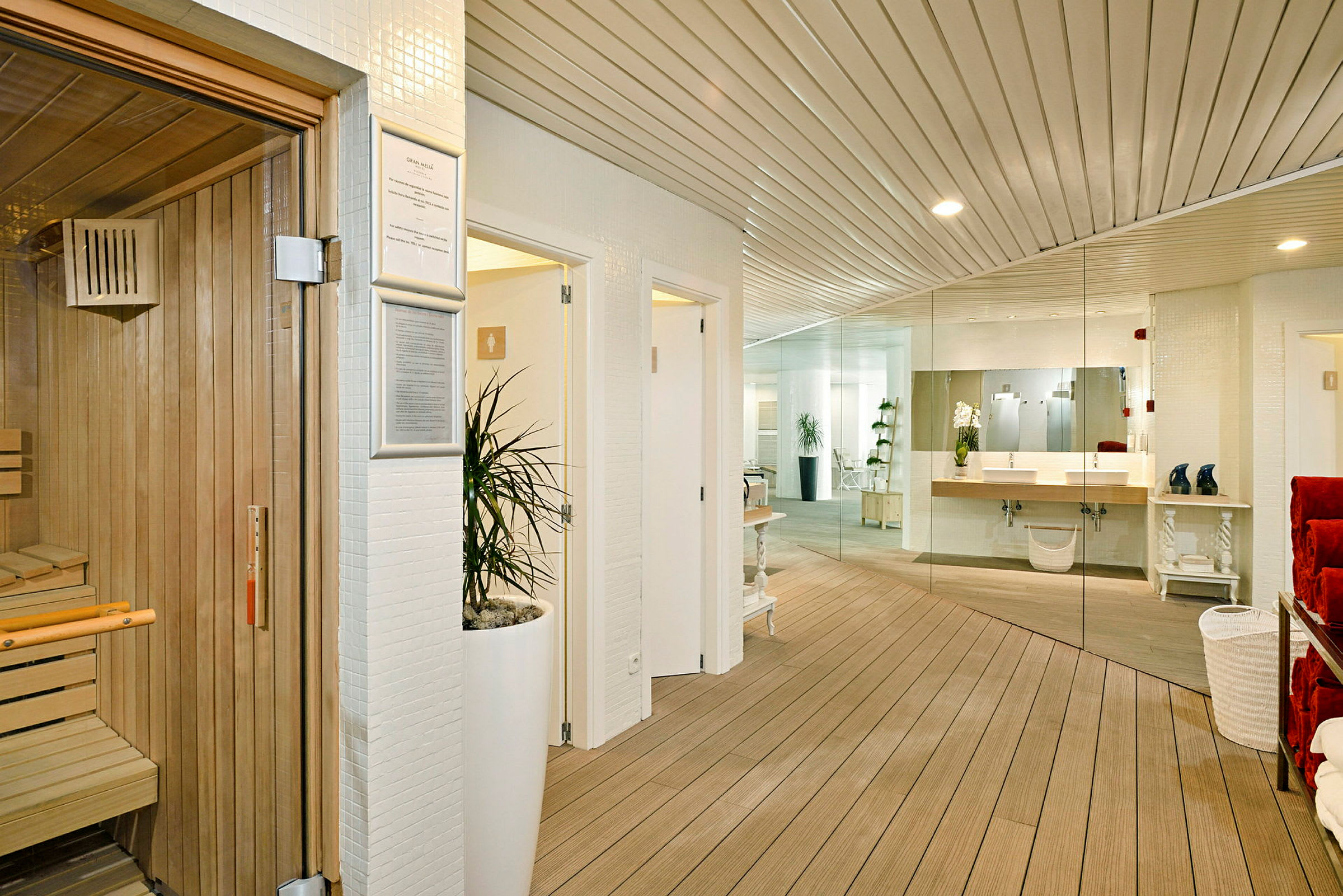 Interiør af et spa med en sauna til venstre, et te-køkkenområde og spejl væg i baggrunden. (AI-genereret tekst)
