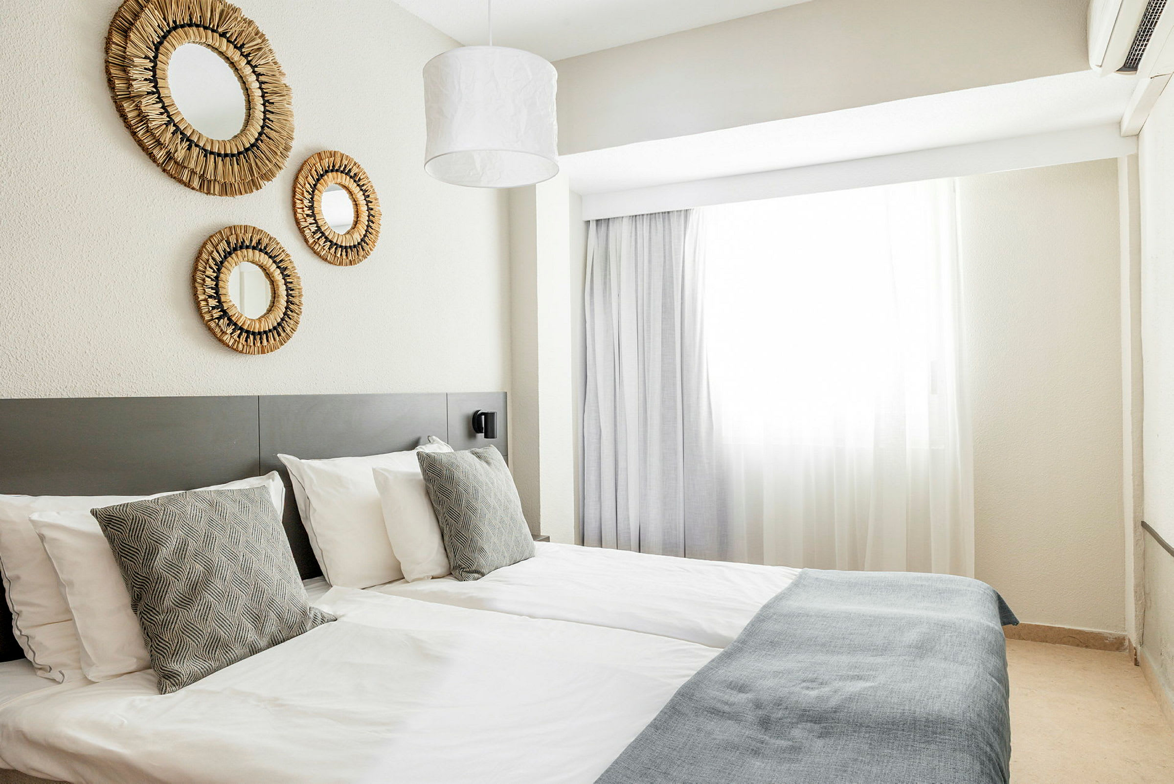 Hotelværelse med to enkeltsenge og vægdekorationer. (AI-genereret tekst)