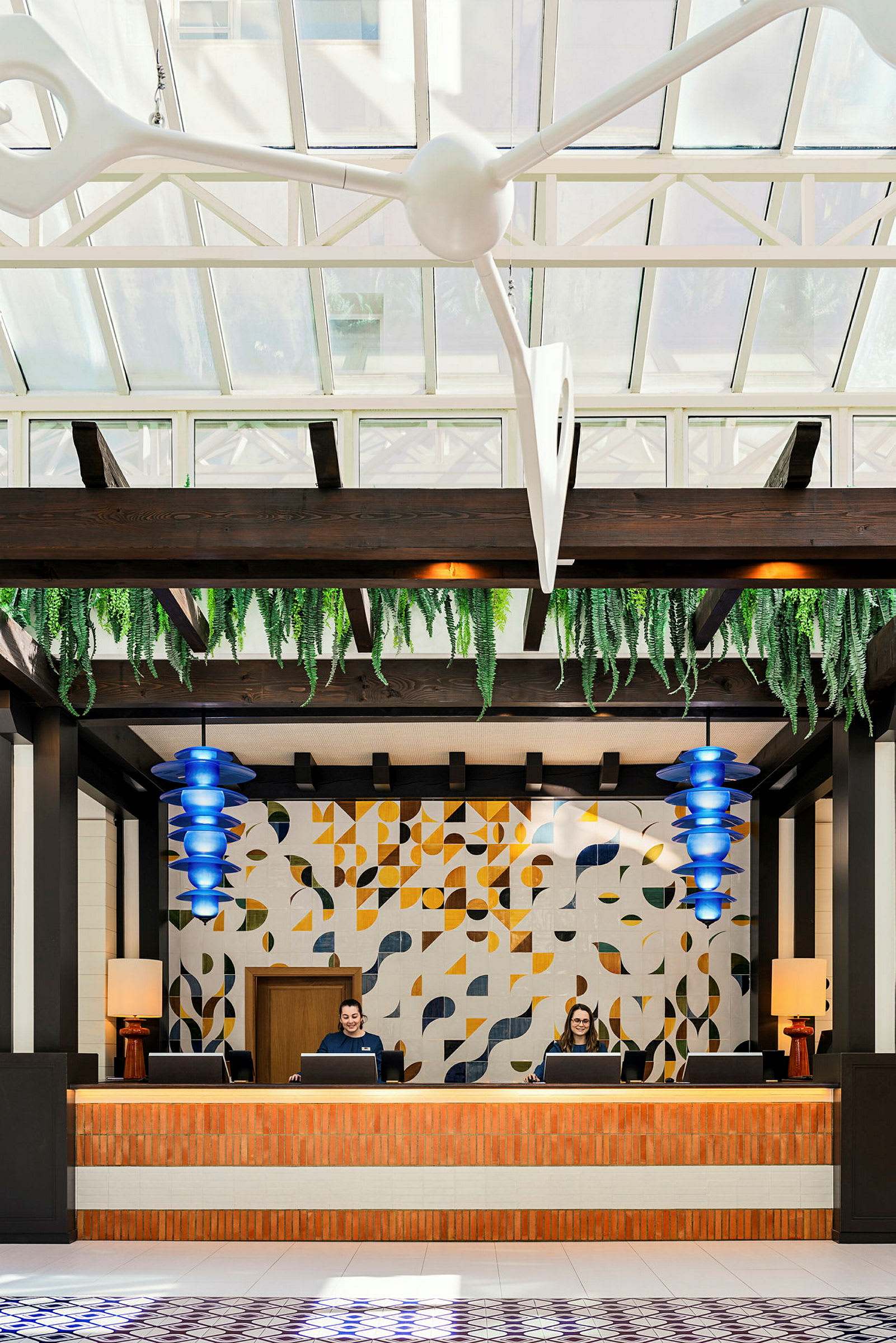 Receptionen på et hotel med udsmykket væg og loft med grønne planter. (AI-genereret tekst)