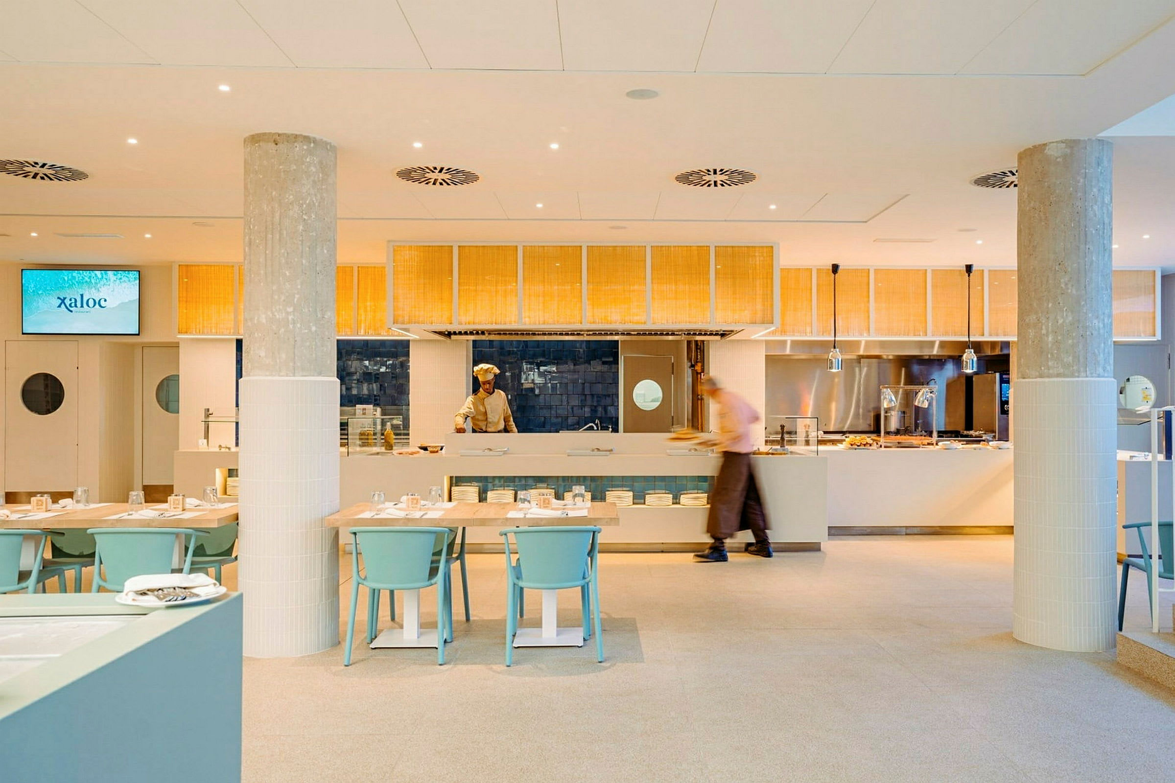 Restaurant med åbent køkken og moderne møbler. (AI-genereret tekst)