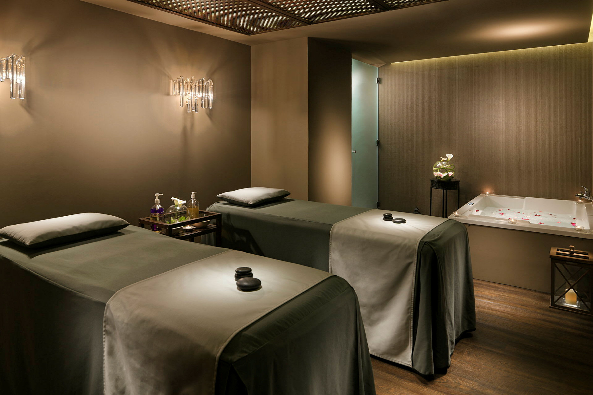 Et behandlingsrum på spa med to behandlingssenge og et badekar. (AI-genereret tekst)