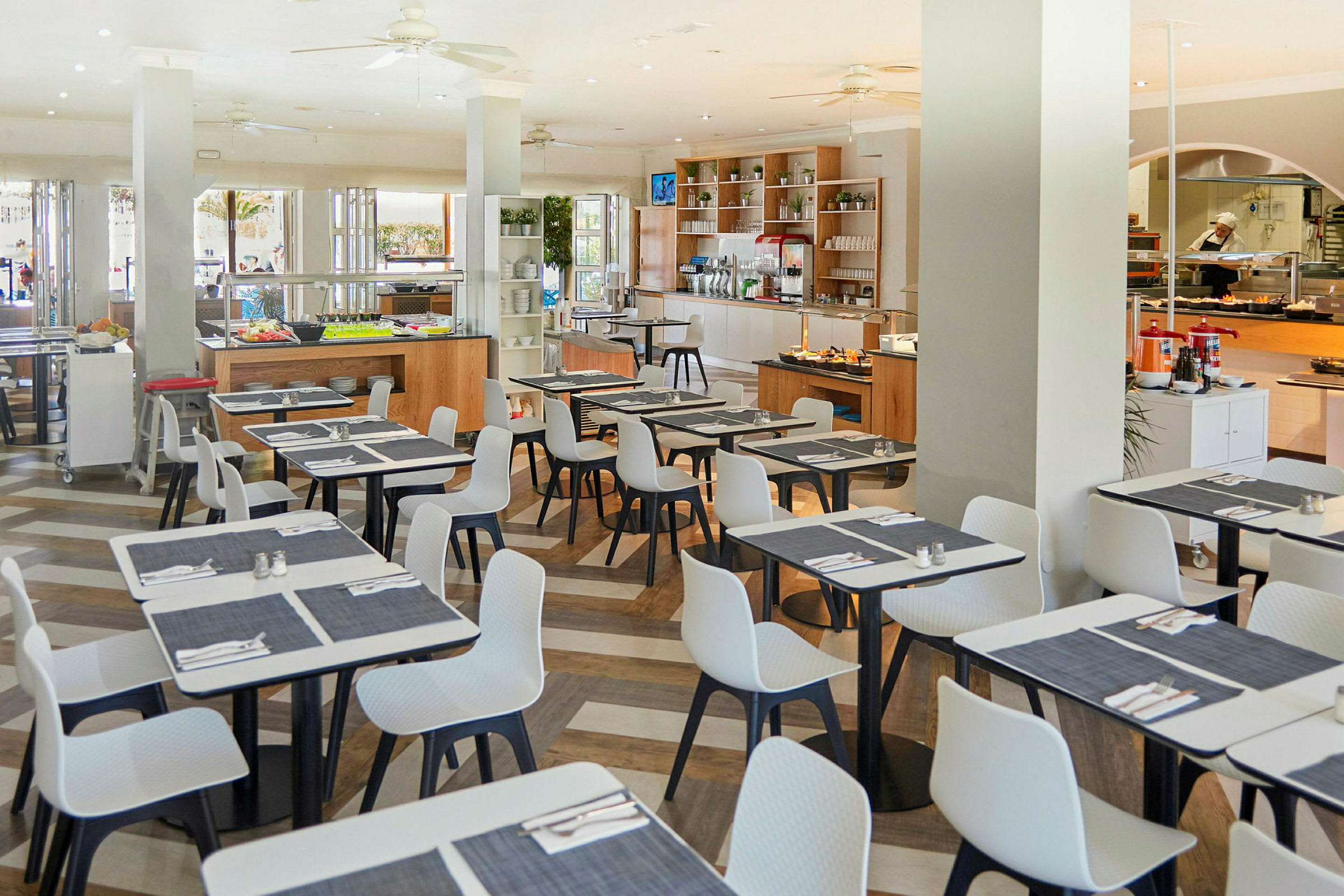 Billede af en restaurant med dækkede borde og en madbuffet. (AI-genereret tekst)