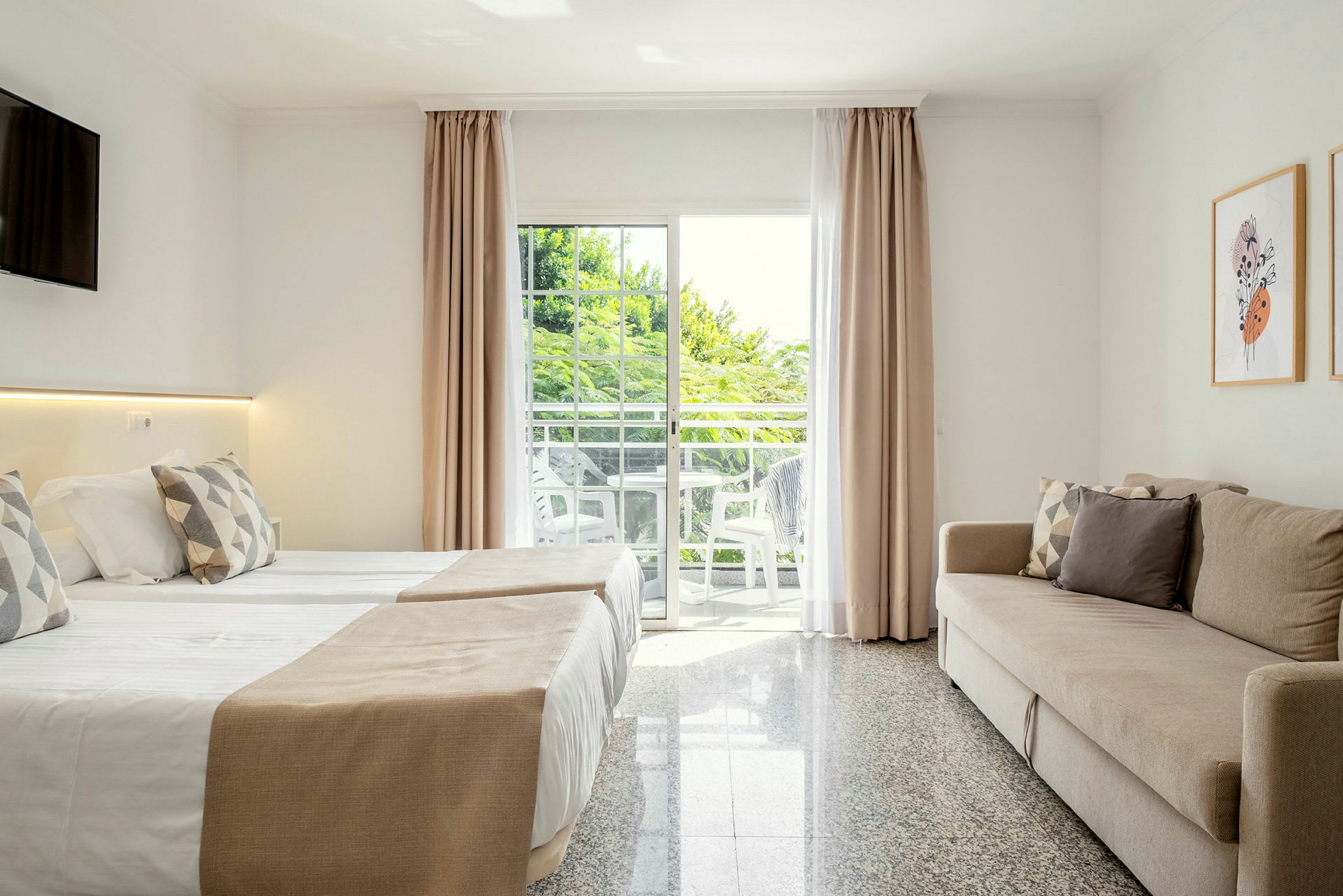 Moderne hotelværelse interiør med en sovesofa, to senge og en balkon med udsigt. (AI-genereret tekst)