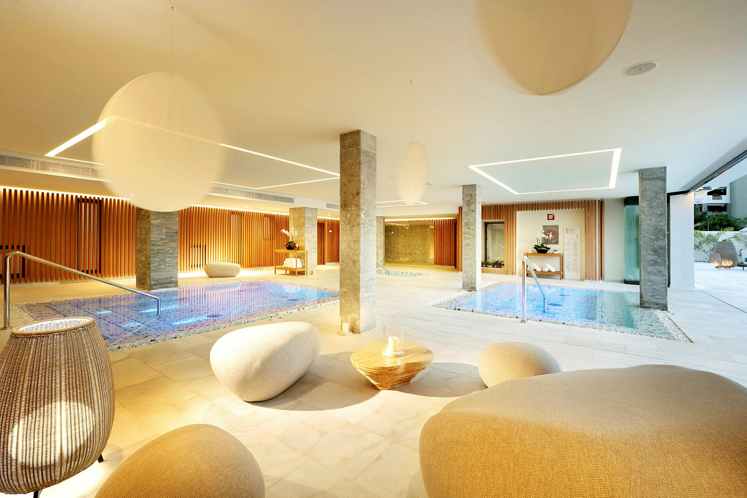 Et moderne spa med indendørs swimmingpools, siddeområder og elegant belysning. (AI-genereret tekst)