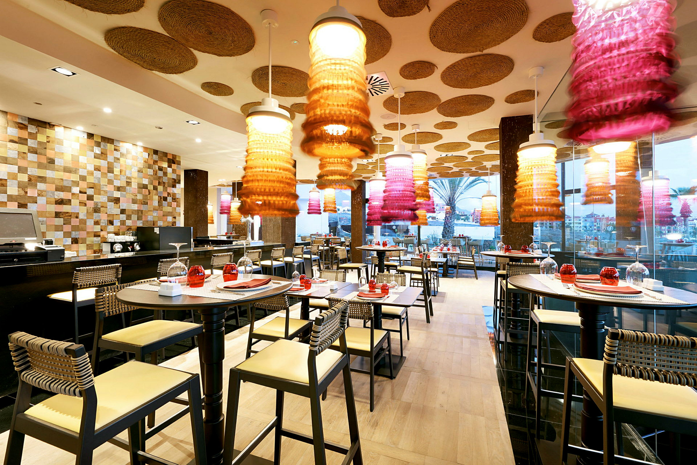 Moderne restaurant med dekorative loftlamper og dækkede borde. (AI-genereret tekst)
