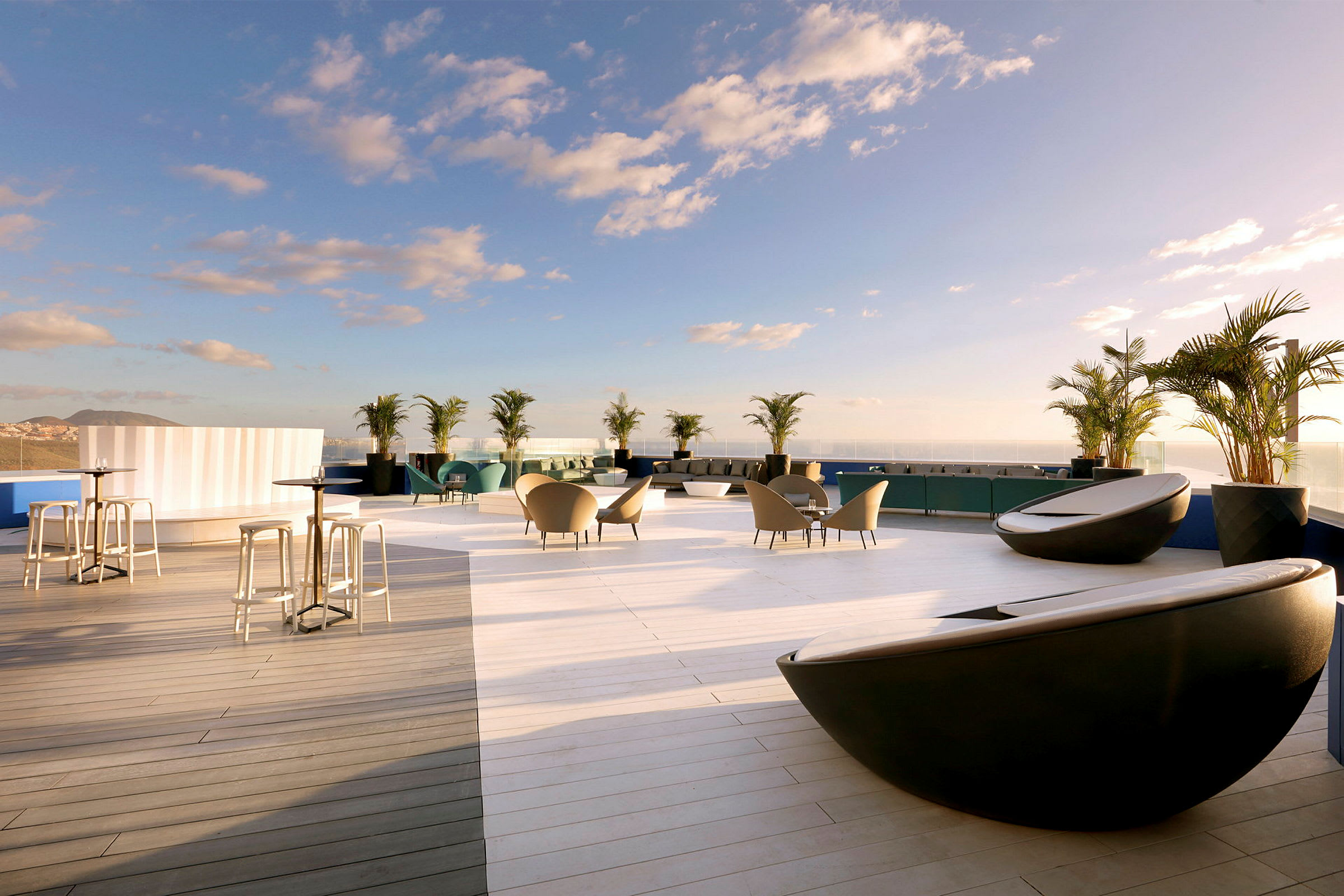 Terrasse med moderne siddearrangementer, borde og dekorationer med havudsigt. (AI-genereret tekst)