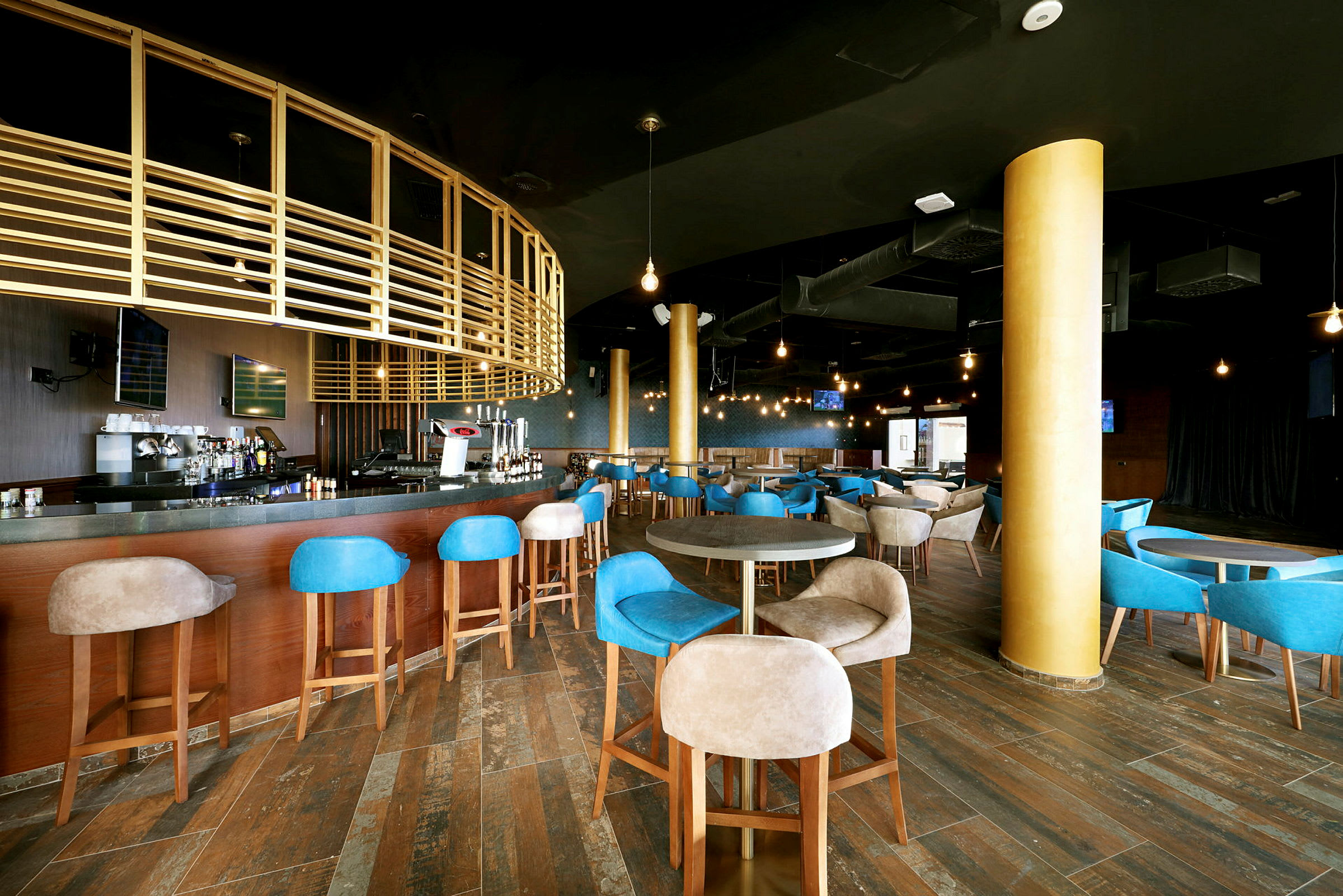Interiør af en moderne bar med træindretning og blå samt beige stole. (AI-genereret tekst)