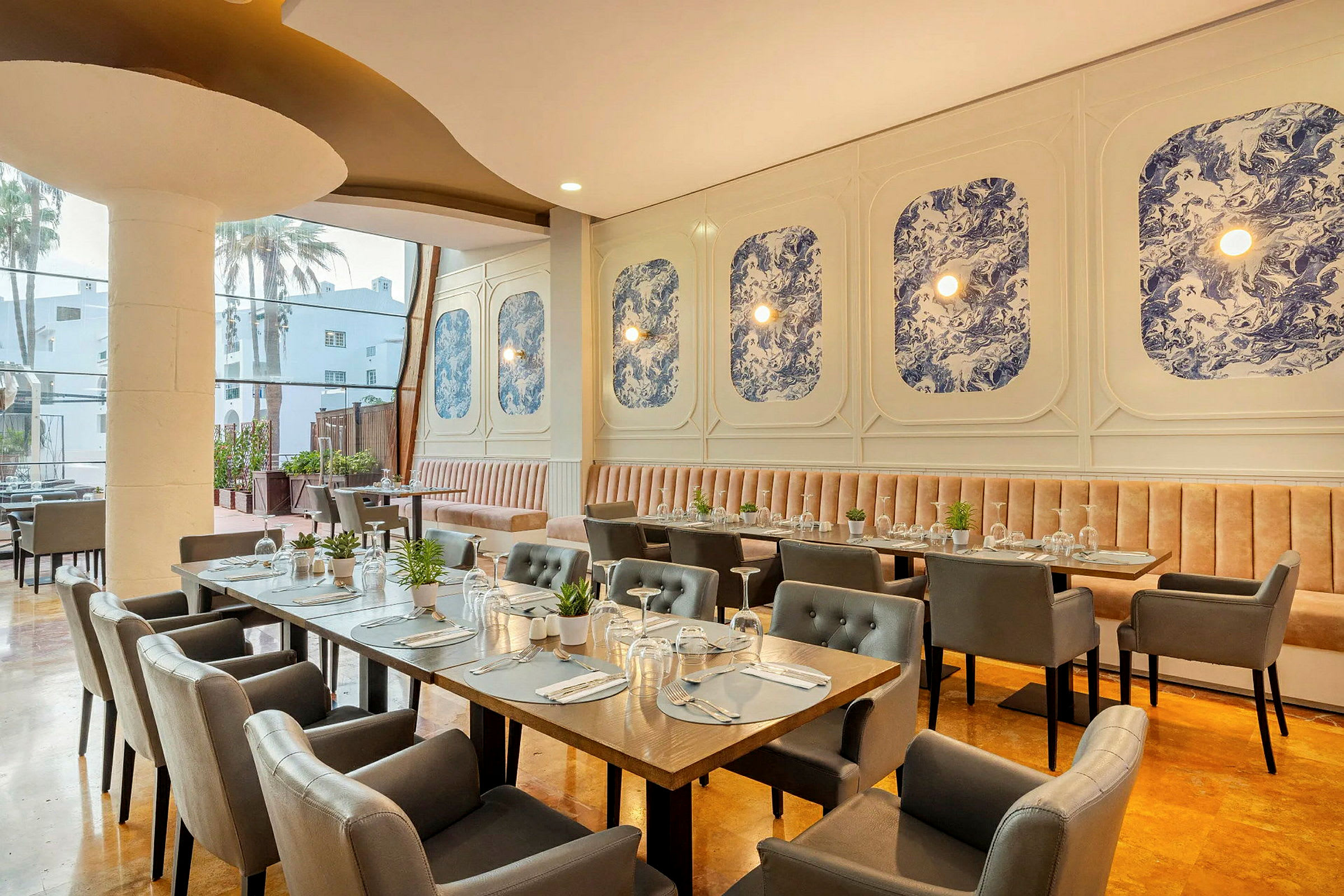 Interiør af en restaurant med elegante borde og stole samt blå dekorationer på væggen. (AI-genereret tekst)
