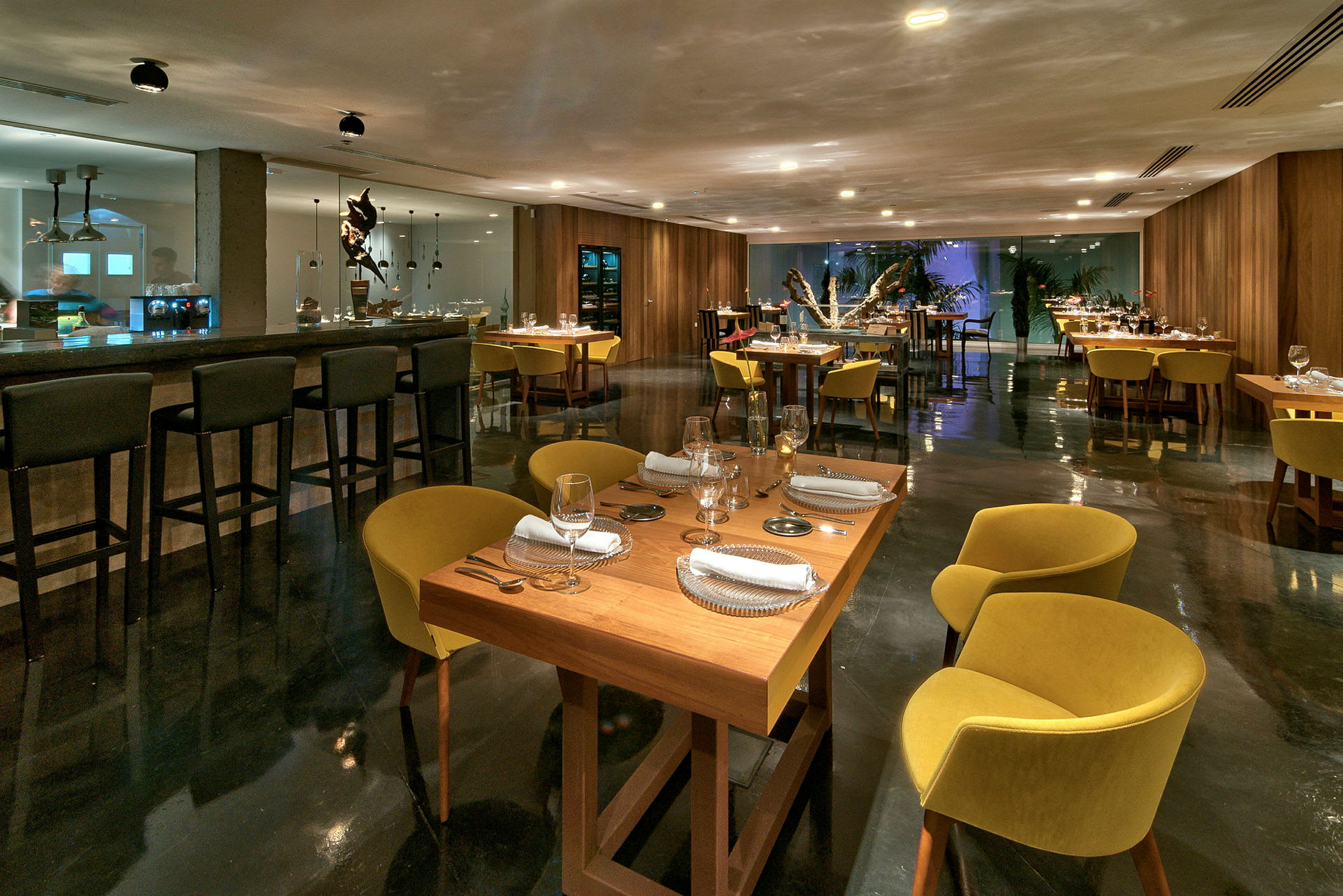 Elegant restaurant med dækkede borde og guldfarvede stole. (AI-genereret tekst)