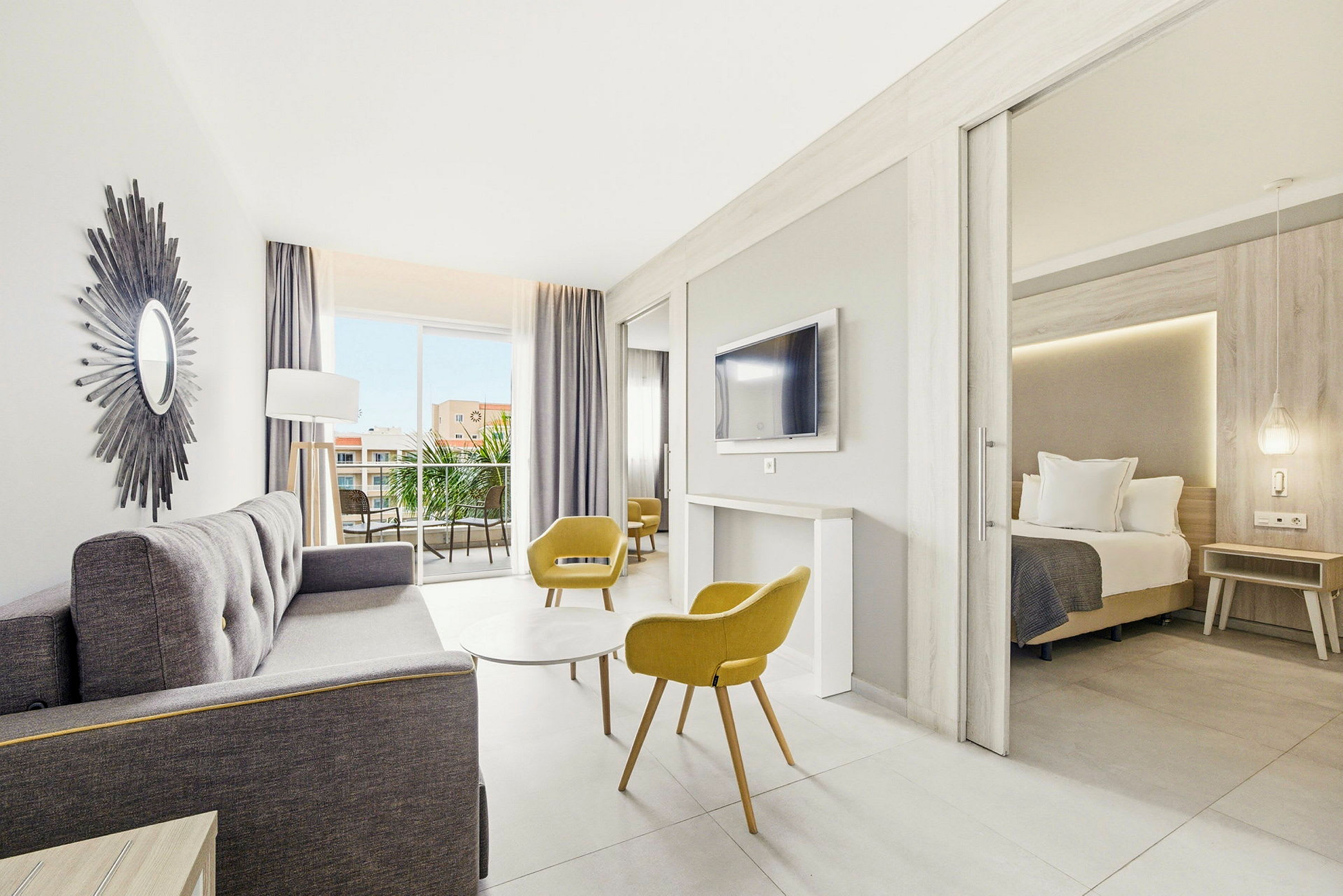 Lyst og moderne hotelværelse med siddeområde, soveværelse og altan. (AI-genereret tekst)