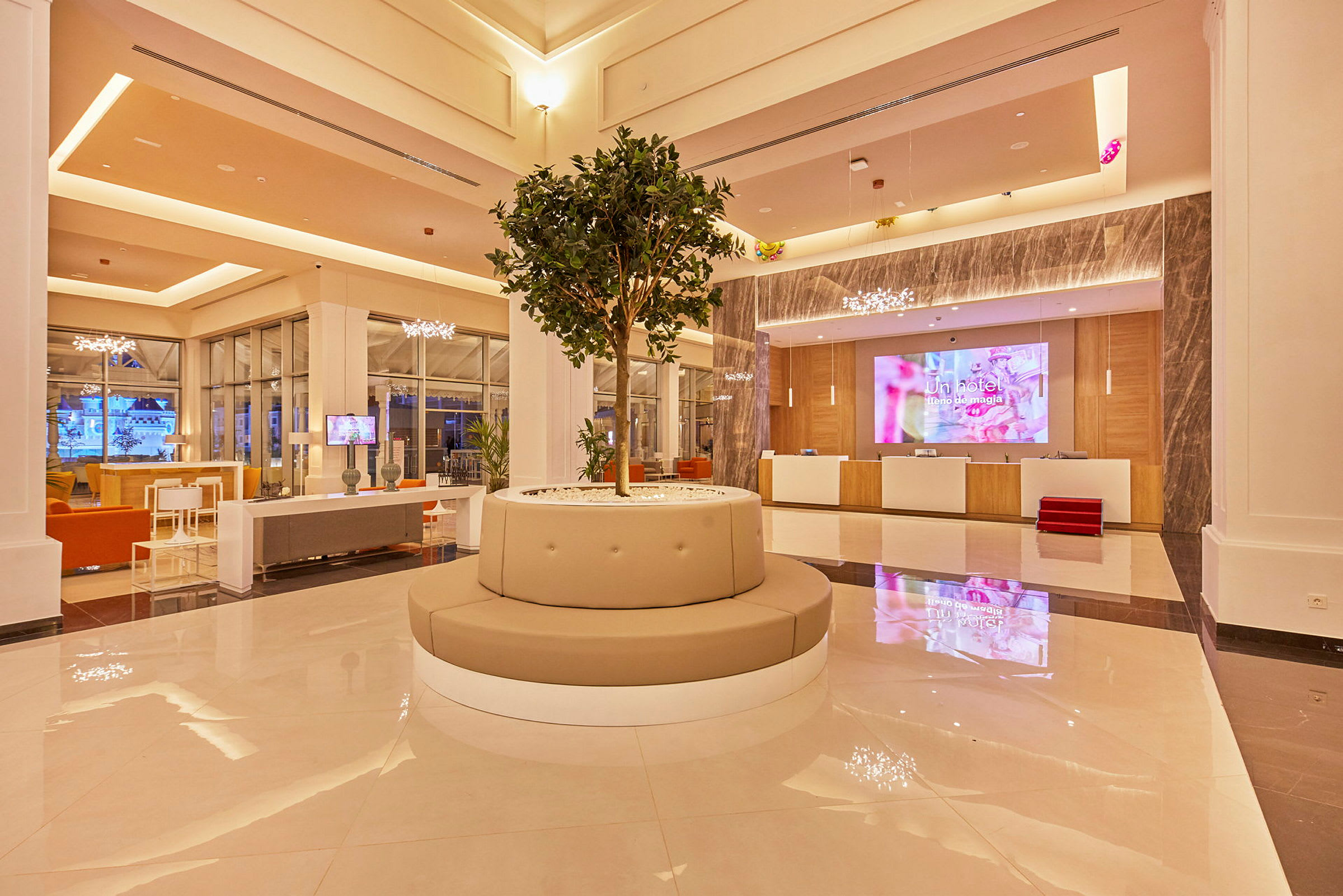 Hotellobby med centralt placeret siddeplads og træ. (AI-genereret tekst)