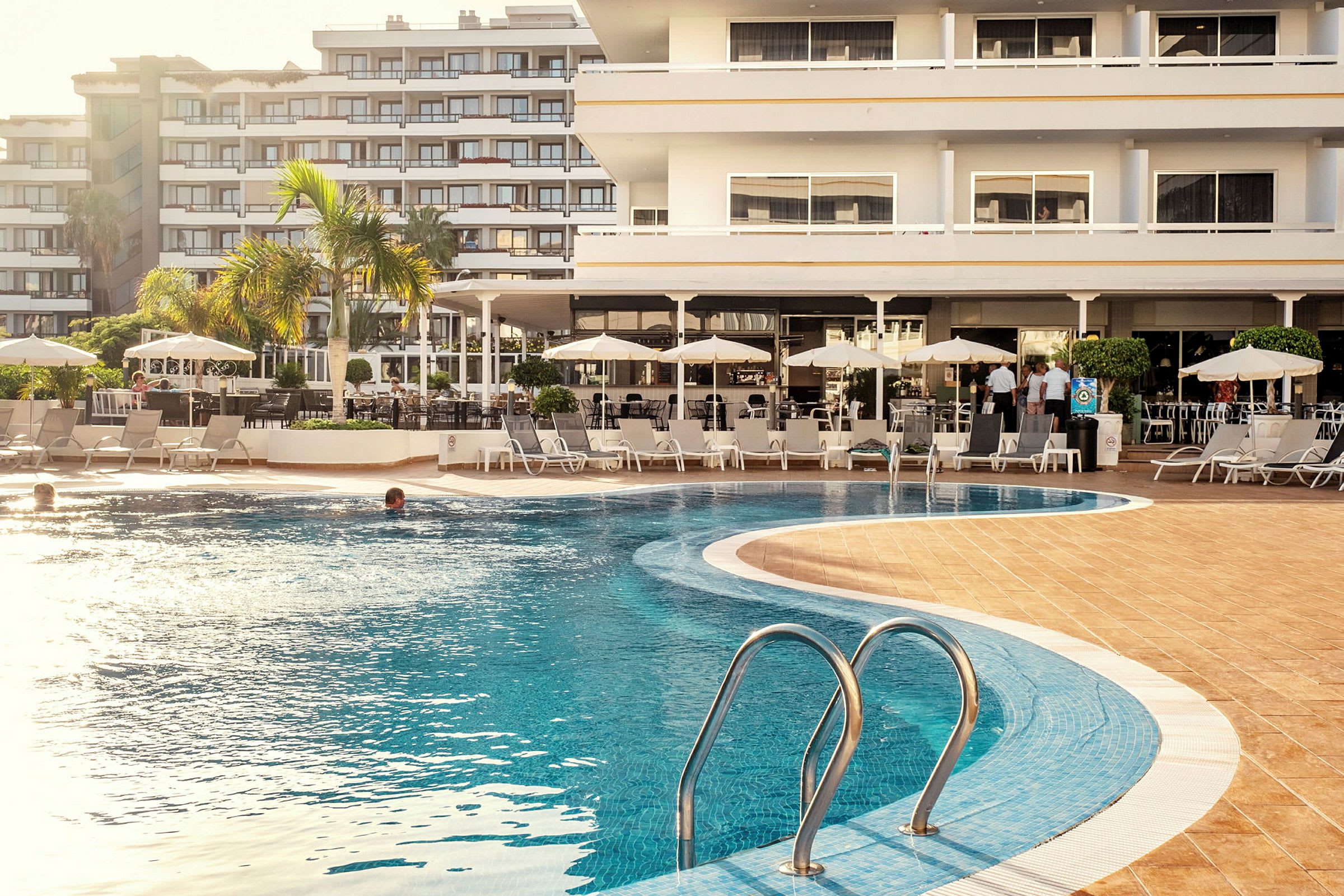 Udendørs pool foran et hotel. (AI-genereret tekst)