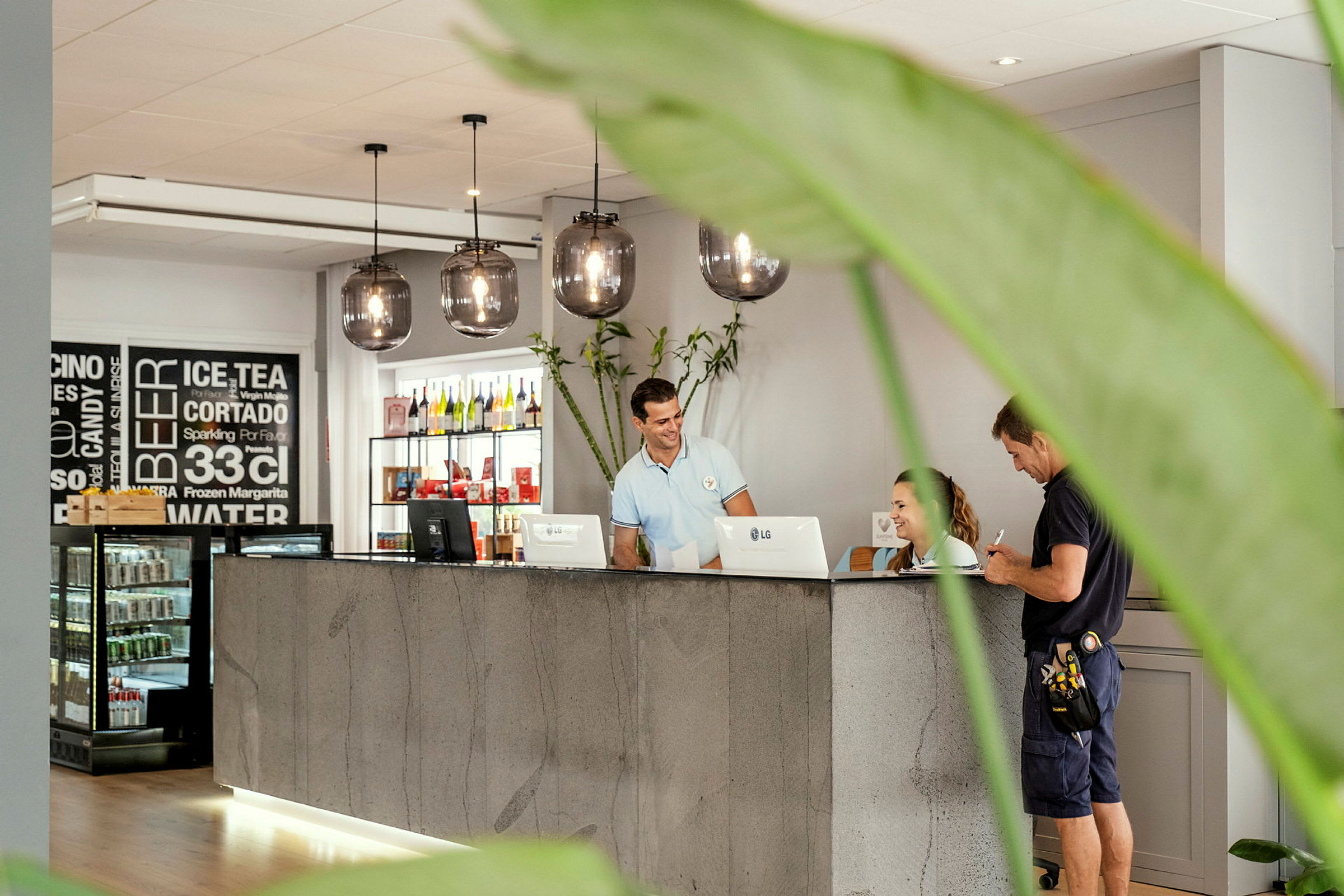 Reception med en betonbord, hængende lamper og plantepynt. (AI-genereret tekst)