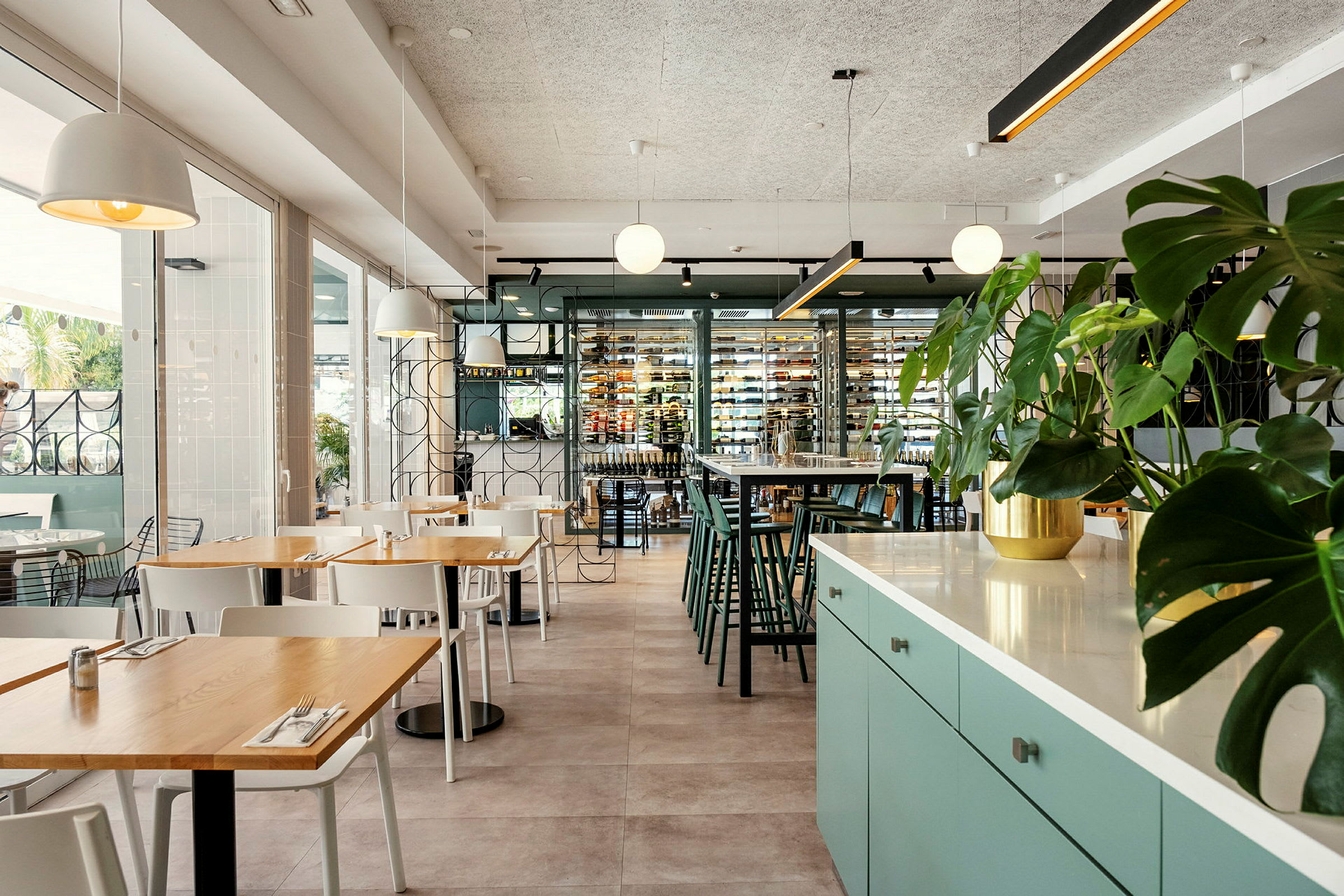 Interiør af en moderne restaurant med siddegrupper og grønne planter. (AI-genereret tekst)