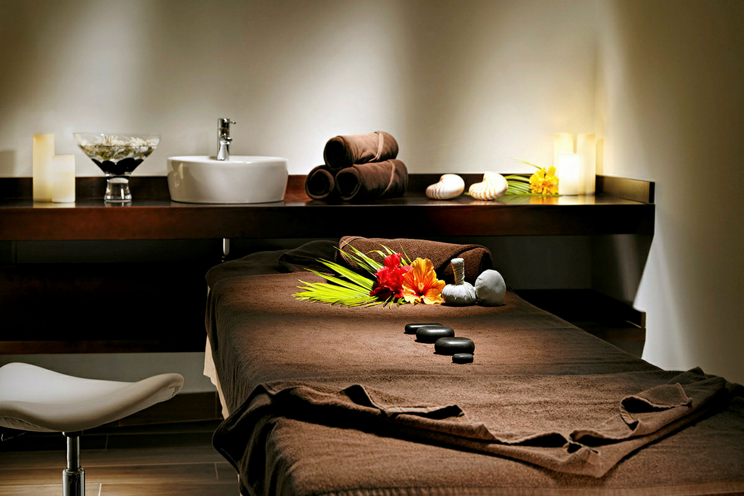 En massagebriks i et oplyst rum med dekorative sten og blomster. (AI-genereret tekst)