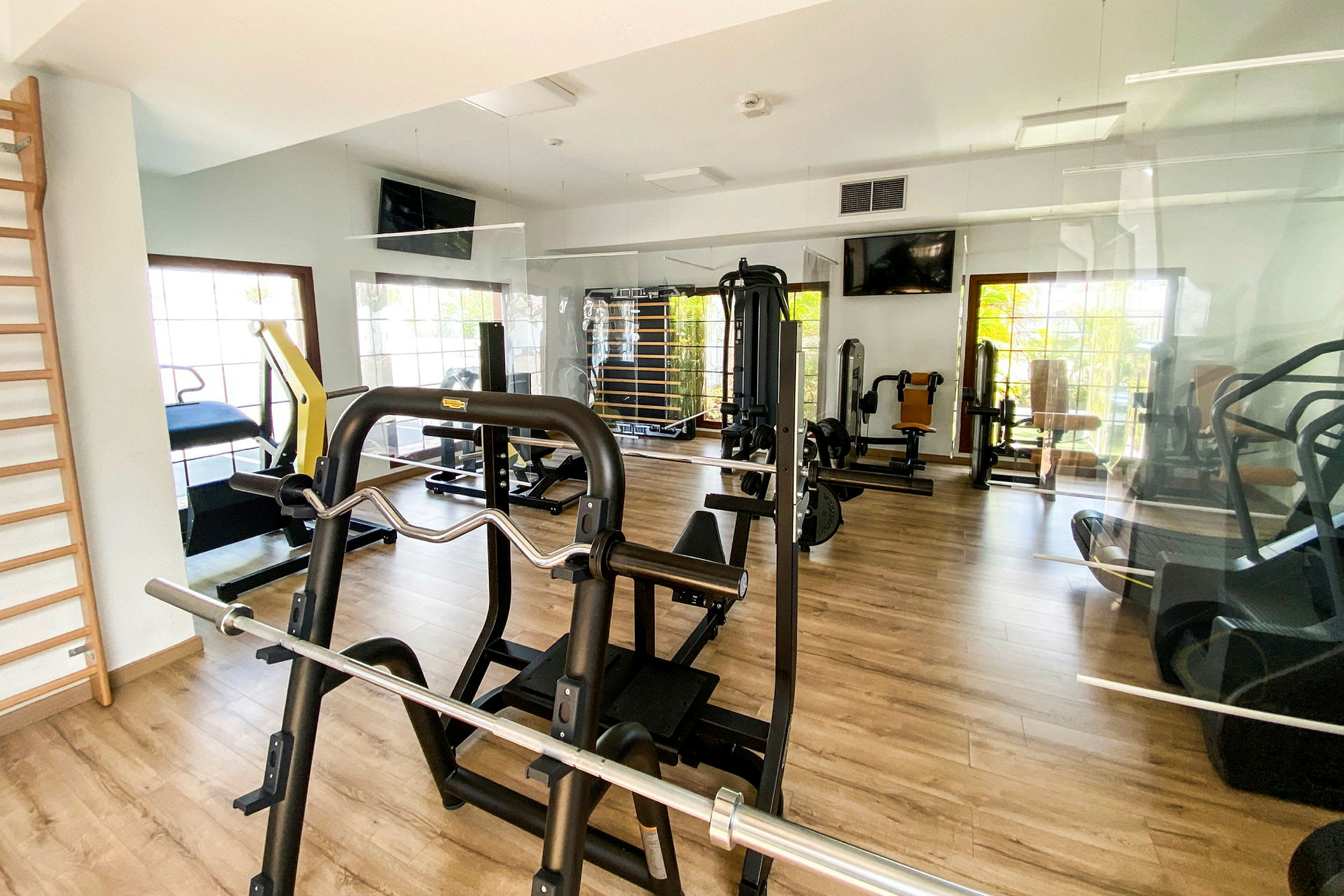 Billede af et fitnesscenter med træningsmaskiner og redskaber. (AI-genereret tekst)