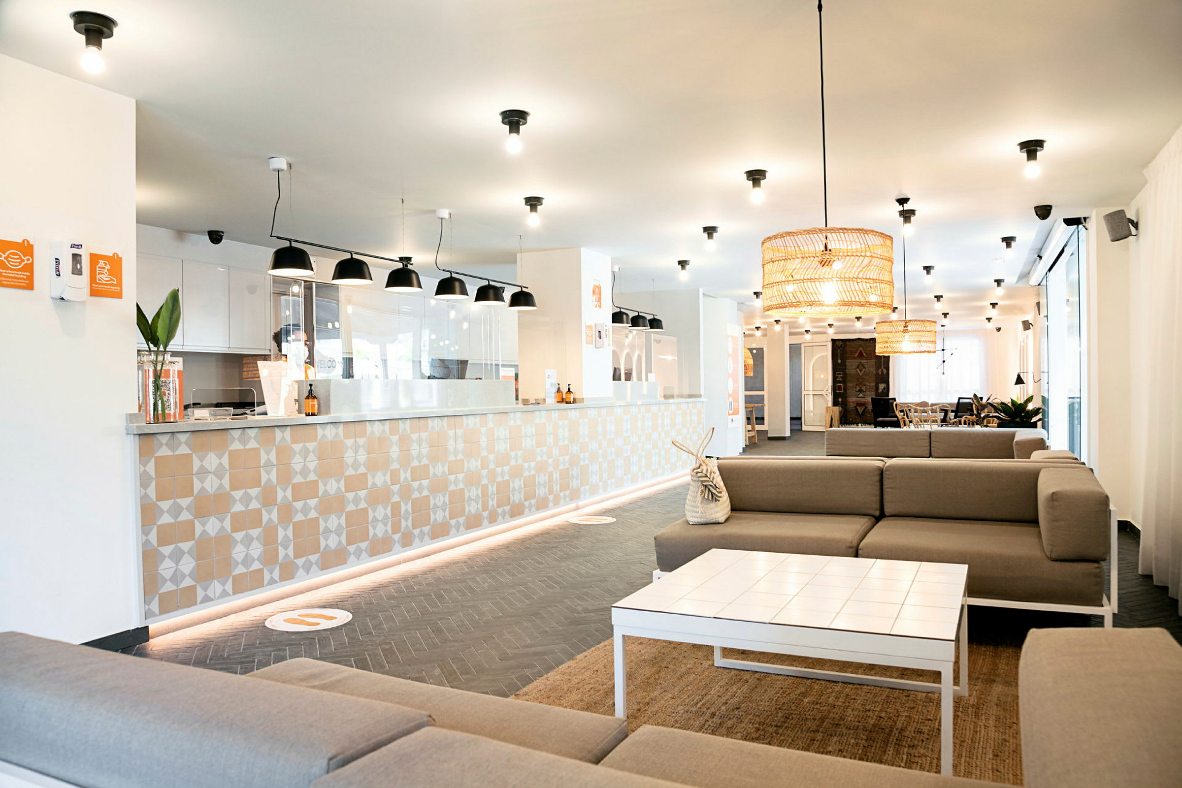 En moderne hotellobby med receptionsskranke og siddegrupper. (AI-genereret tekst)