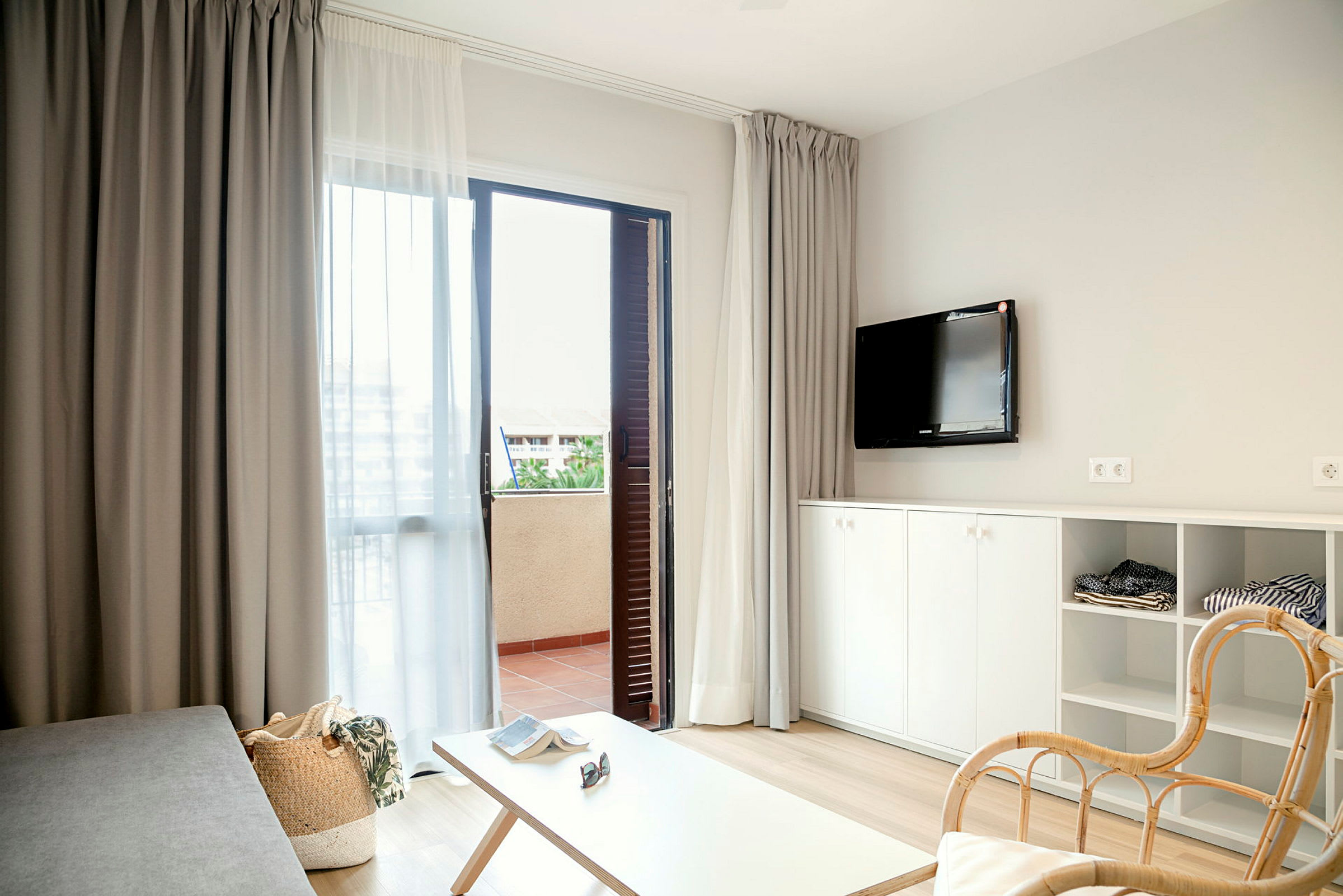 Moderne møbleret hotelværelse med åben dør til balkon. (AI-genereret tekst)