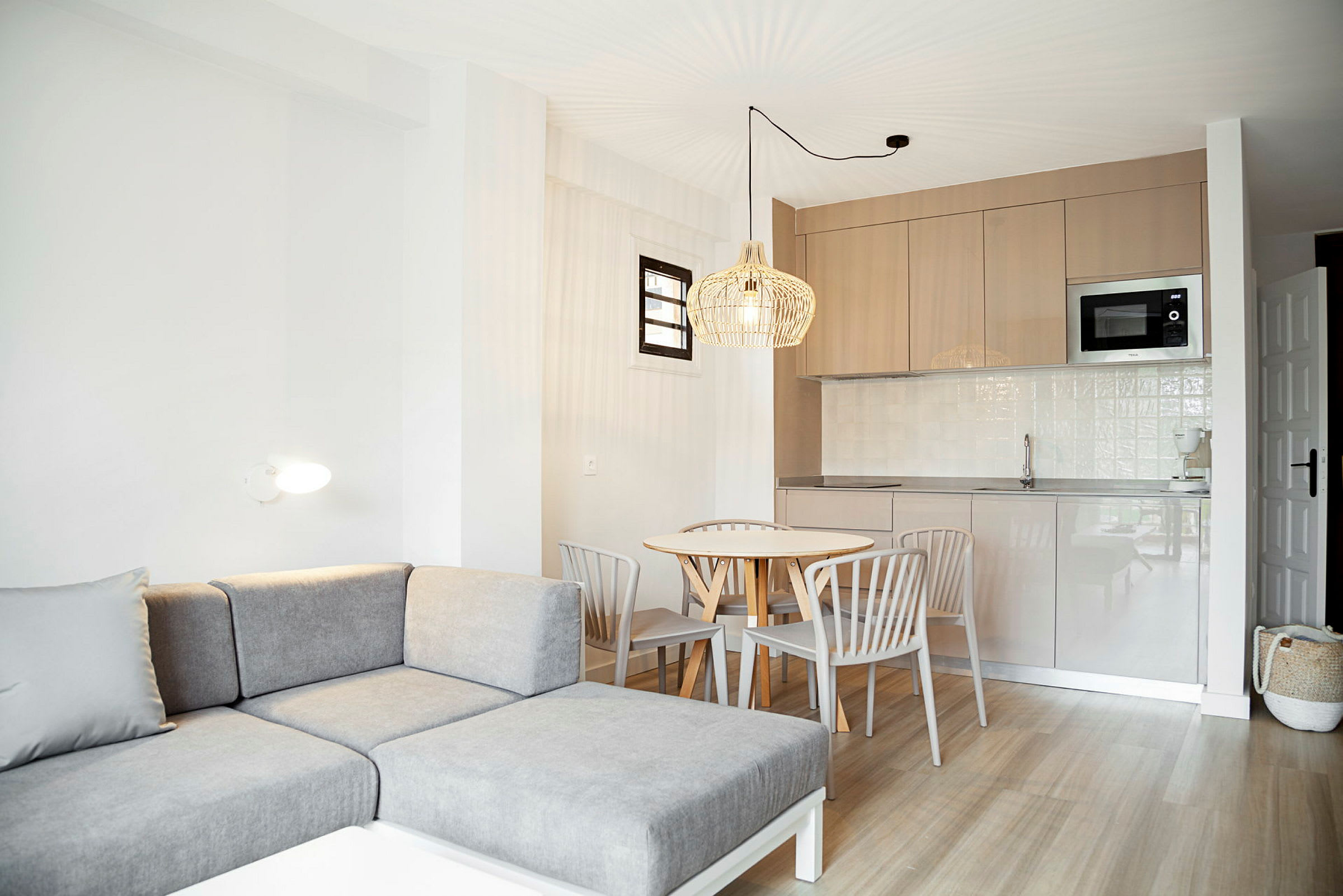 En lys lejlighed med moderne sofa, spisebord og køkken. (AI-genereret tekst)