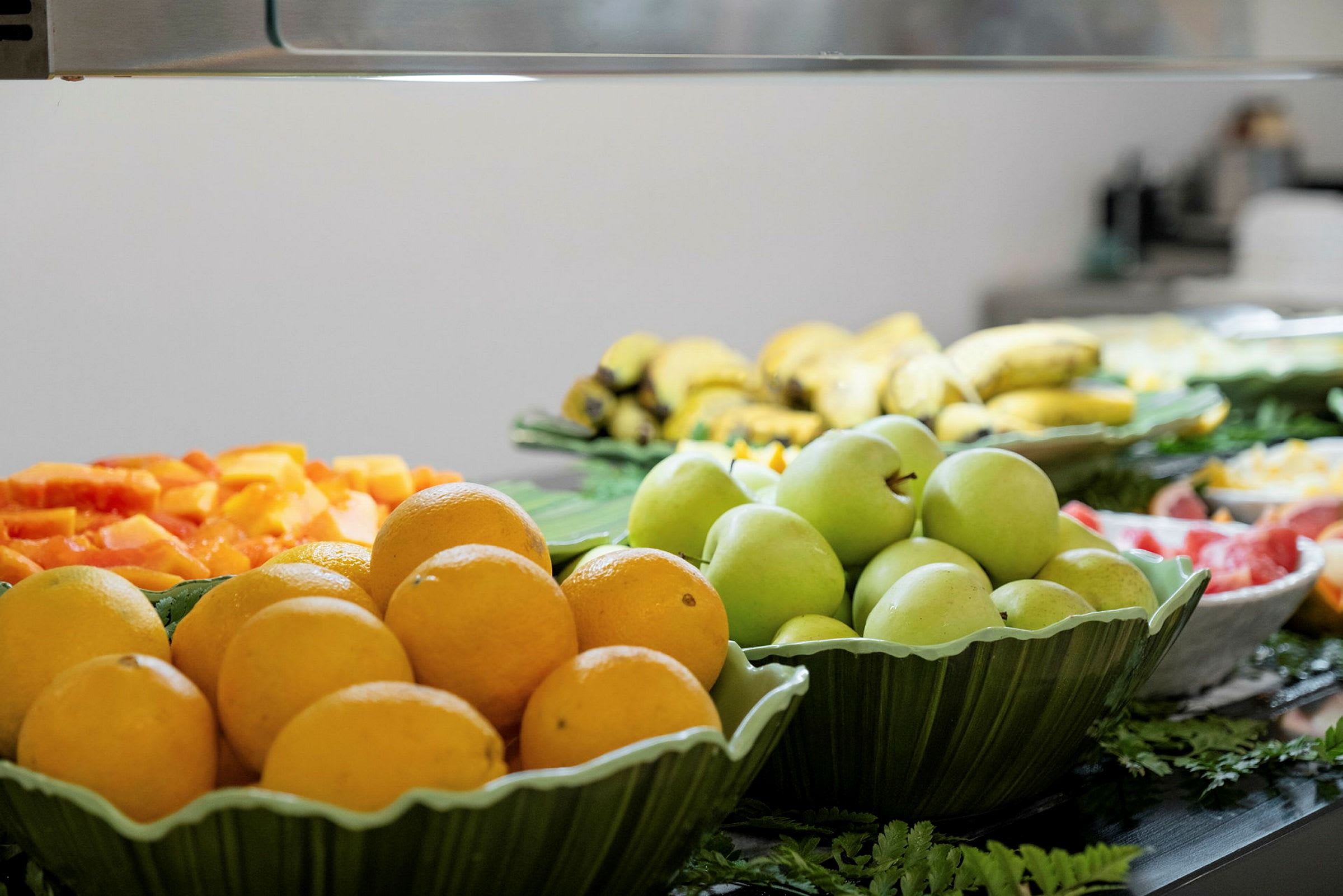 En buffet med forskellige frugter såsom appelsiner, grønne æbler og bananer. (AI-genereret tekst)