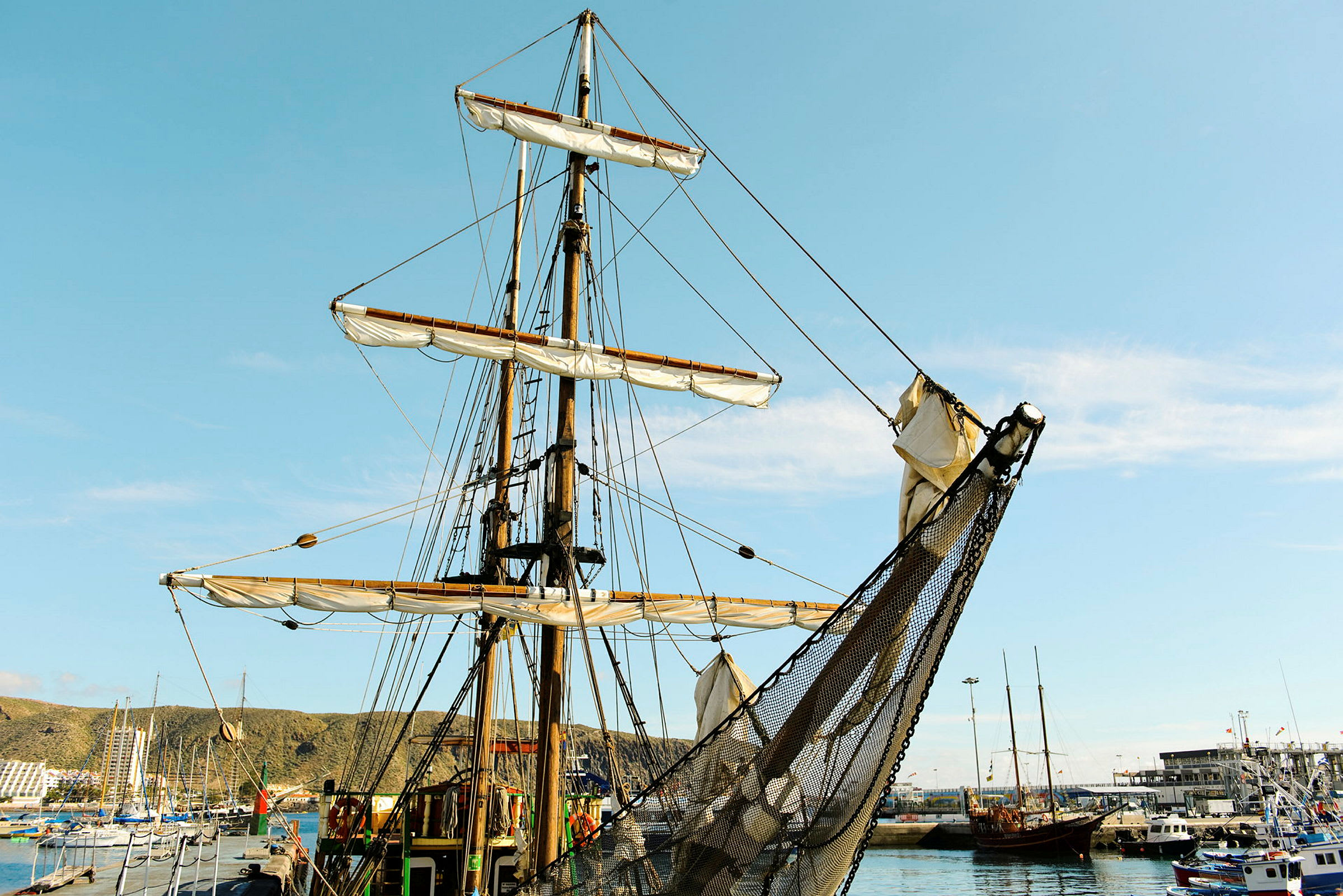 Sejlskib i en havn med blå himmel i baggrunden. (AI-genereret tekst)