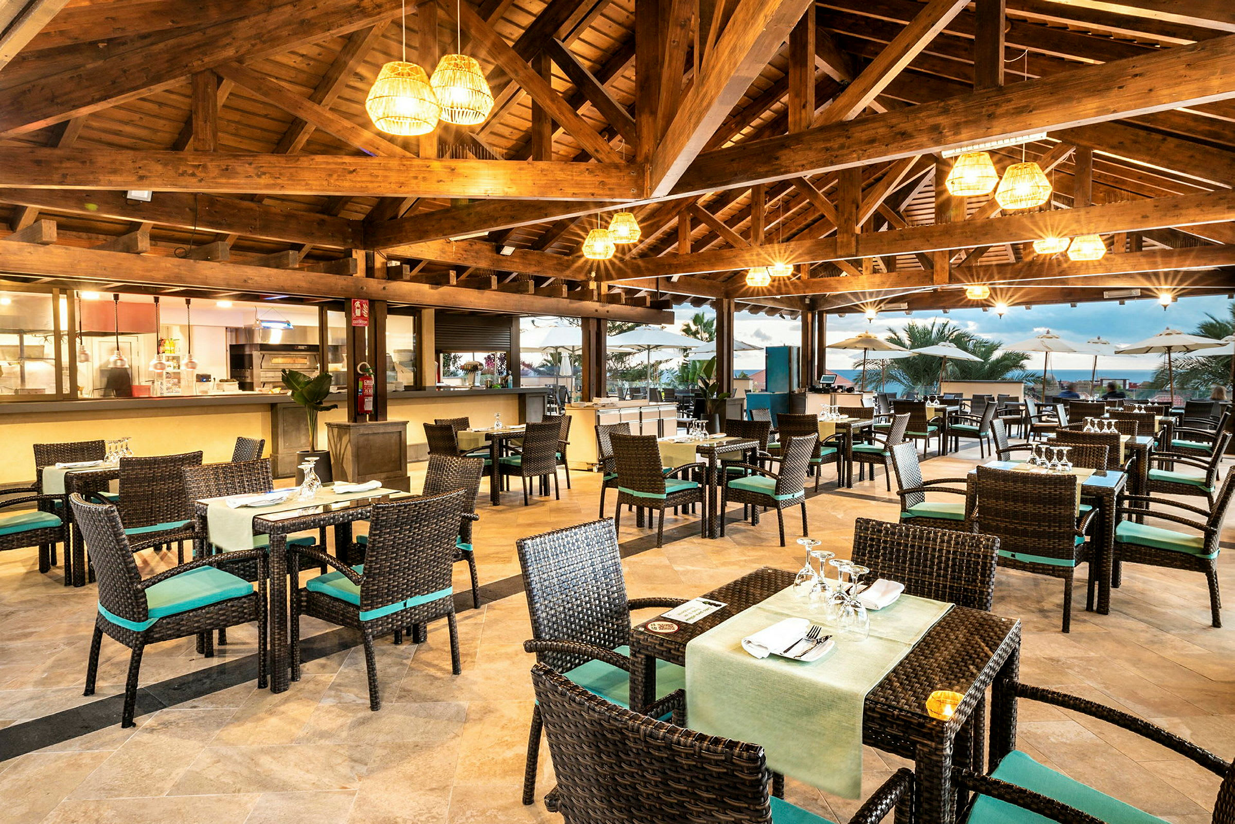 En restaurant med borde og stole, åben tagkonstruktion og udsigt mod en terrasse. (AI-genereret tekst)