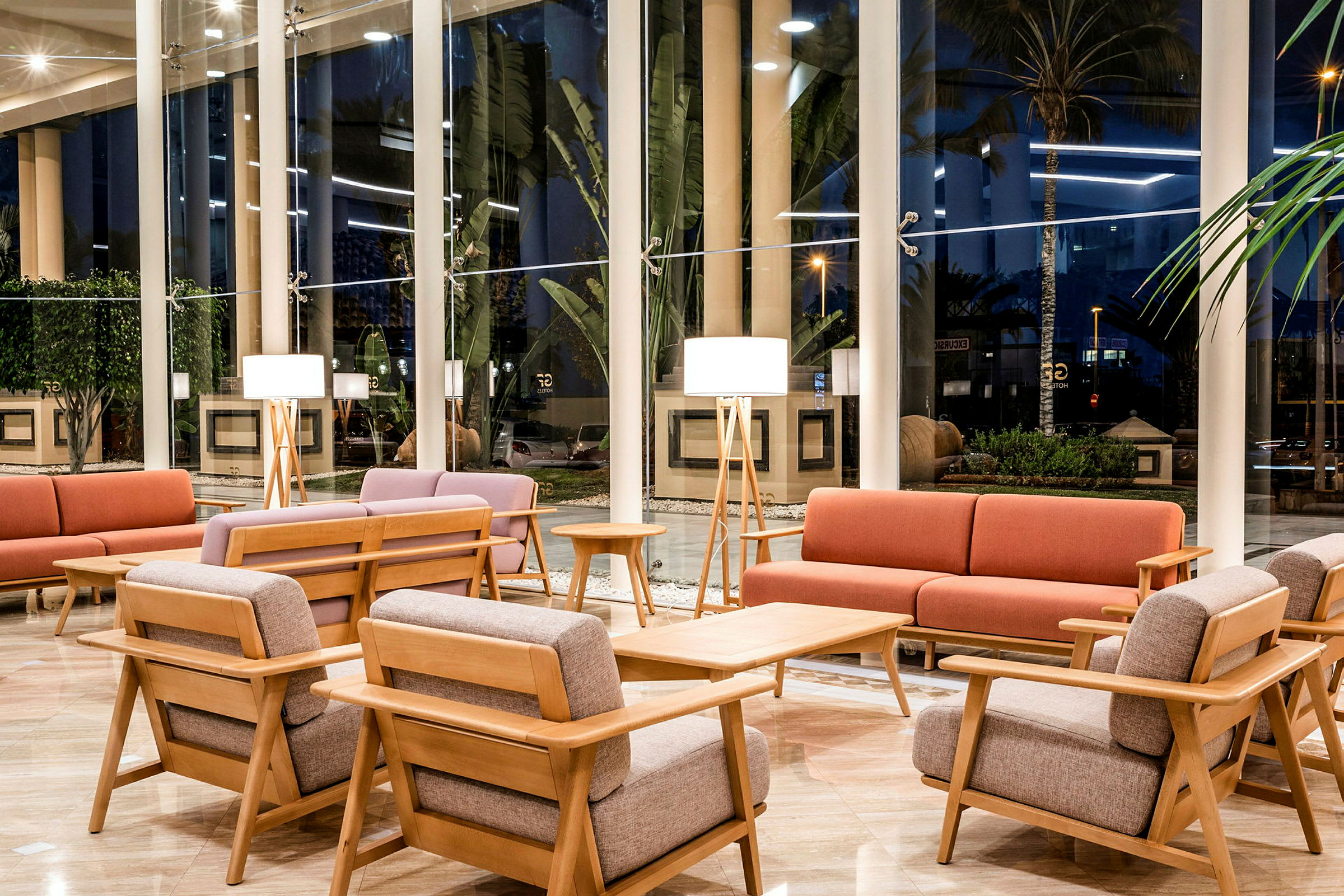 En hotellobby med moderne møbler og store vinduer. (AI-genereret tekst)