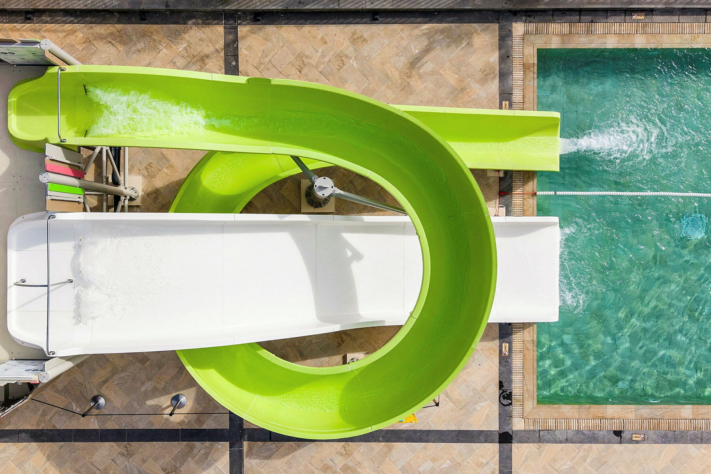 Luftfoto af en snoet vandrutsjebane ved en pool. (AI-genereret tekst)