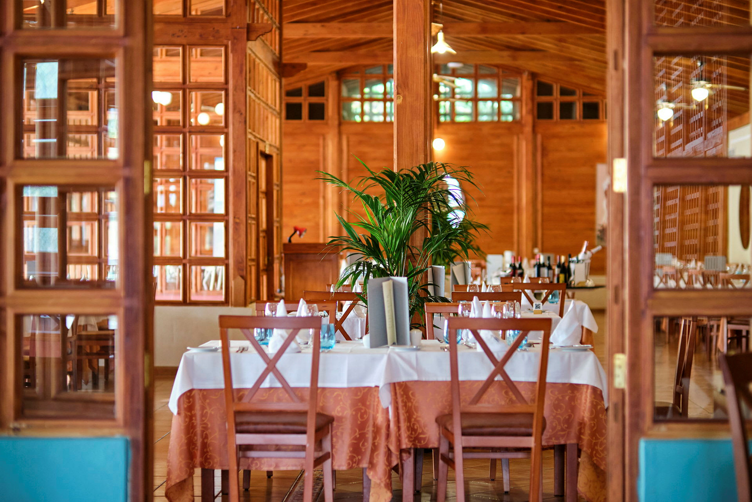 En elegant restaurant med dækkede borde, dekorerede stole og en træudsmykning. (AI-genereret tekst)