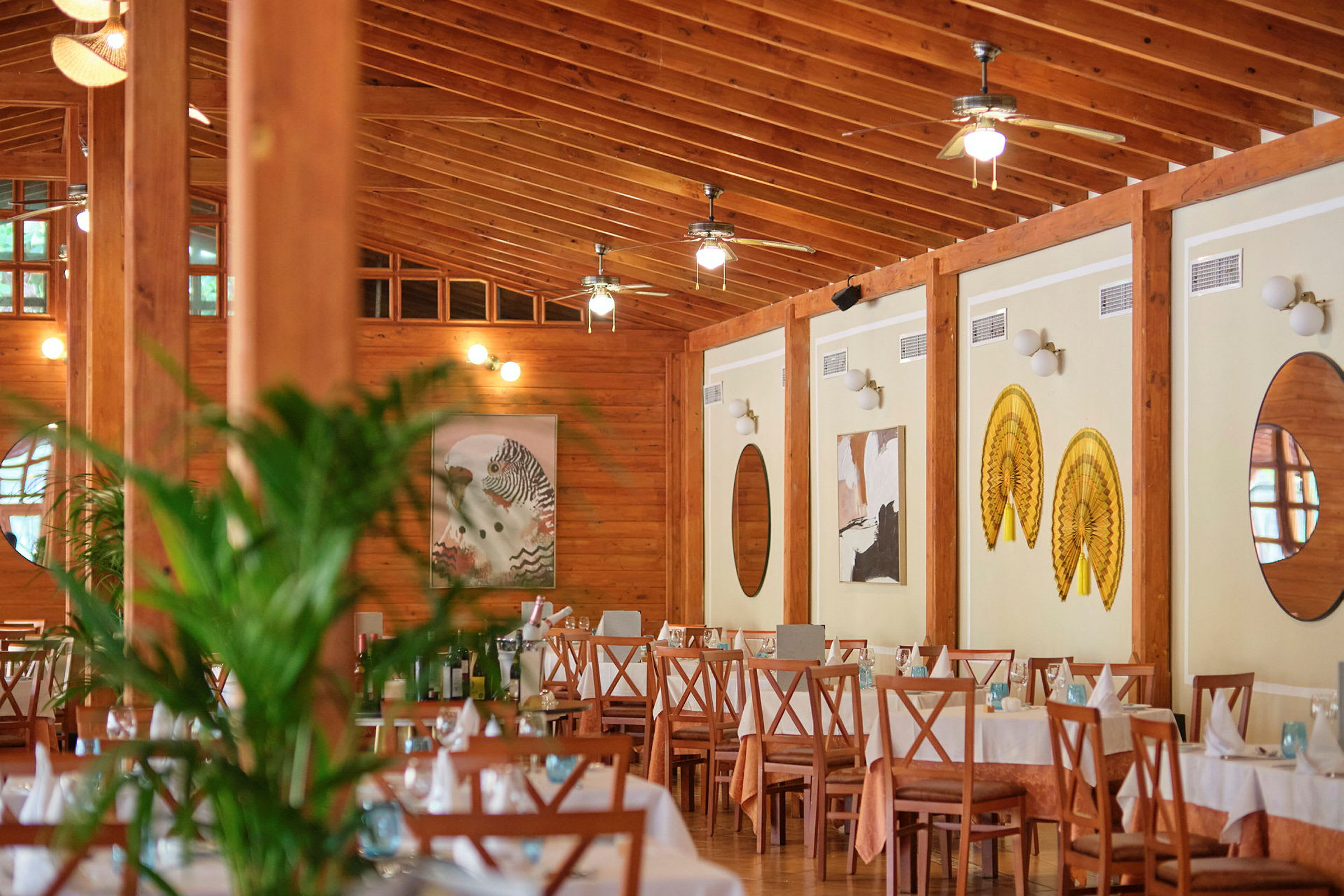 Interiøret i en restaurant med dækkede borde og træindretning. (AI-genereret tekst)
