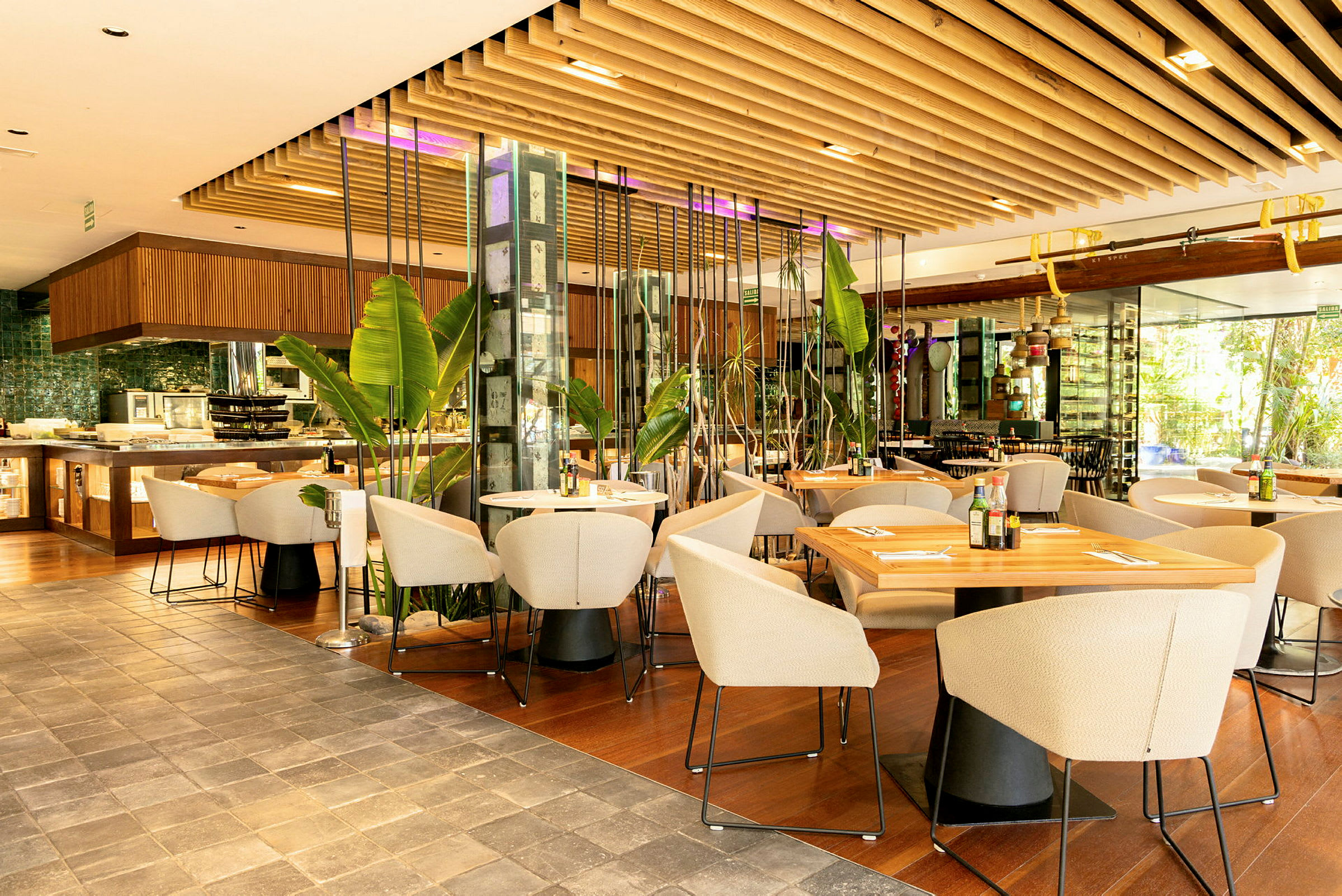 Et moderne restaurantområde med borde, stole og planteudsmykning. (AI-genereret tekst)