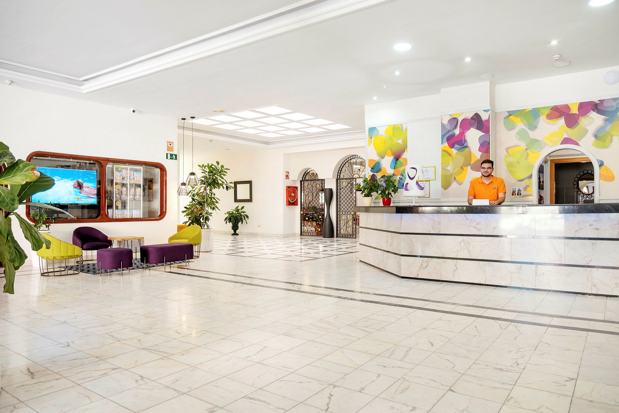 Hotellets receptionsområde med farverigt interiør og moderne møbler. (AI-genereret tekst)