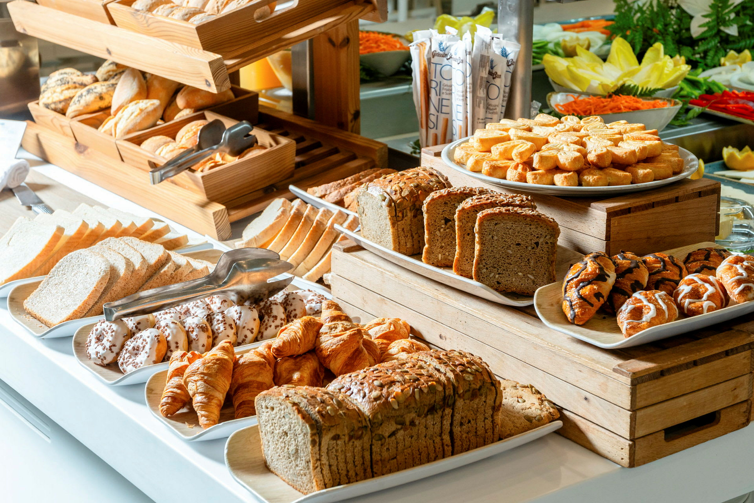 En buffet med forskellige slags brød og bagværk i en serveringsområde. (AI-genereret tekst)
