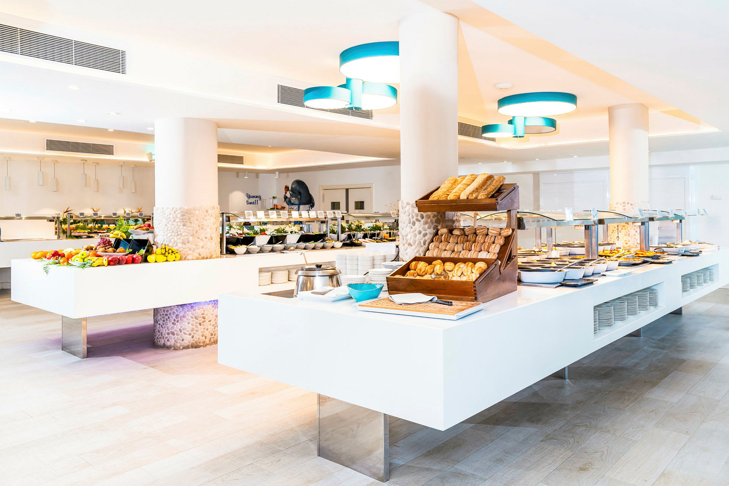 Billede af en hotelbuffet med brød, frugt og varm tilberedt mad. (AI-genereret tekst)