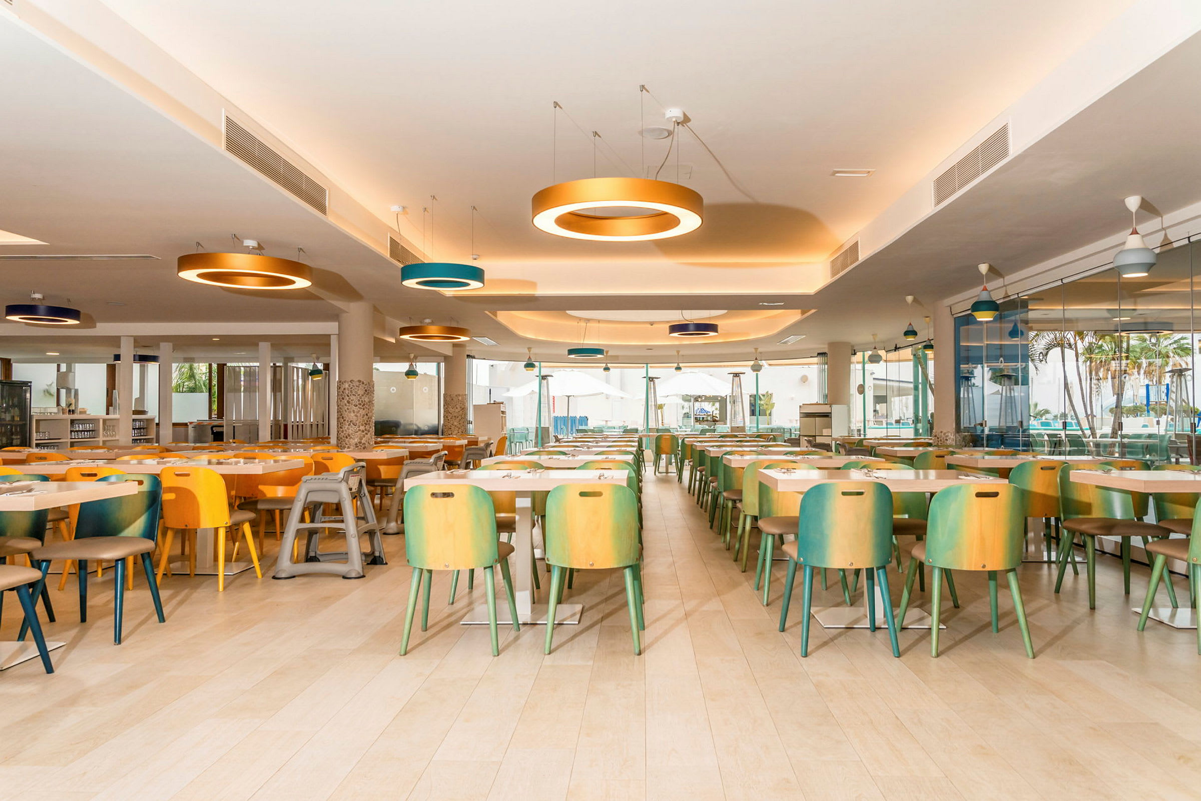 Restaurant med flere farverige stole og borde, moderne belysning. (AI-genereret tekst)