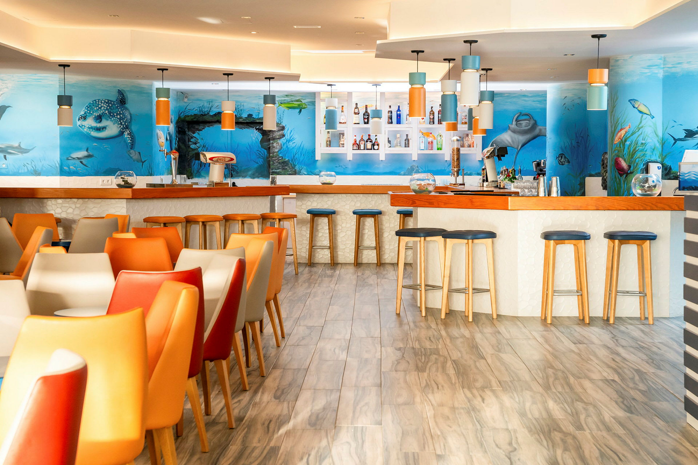 Billede af en farverig restaurant med undervandstema og en bar. (AI-genereret tekst)