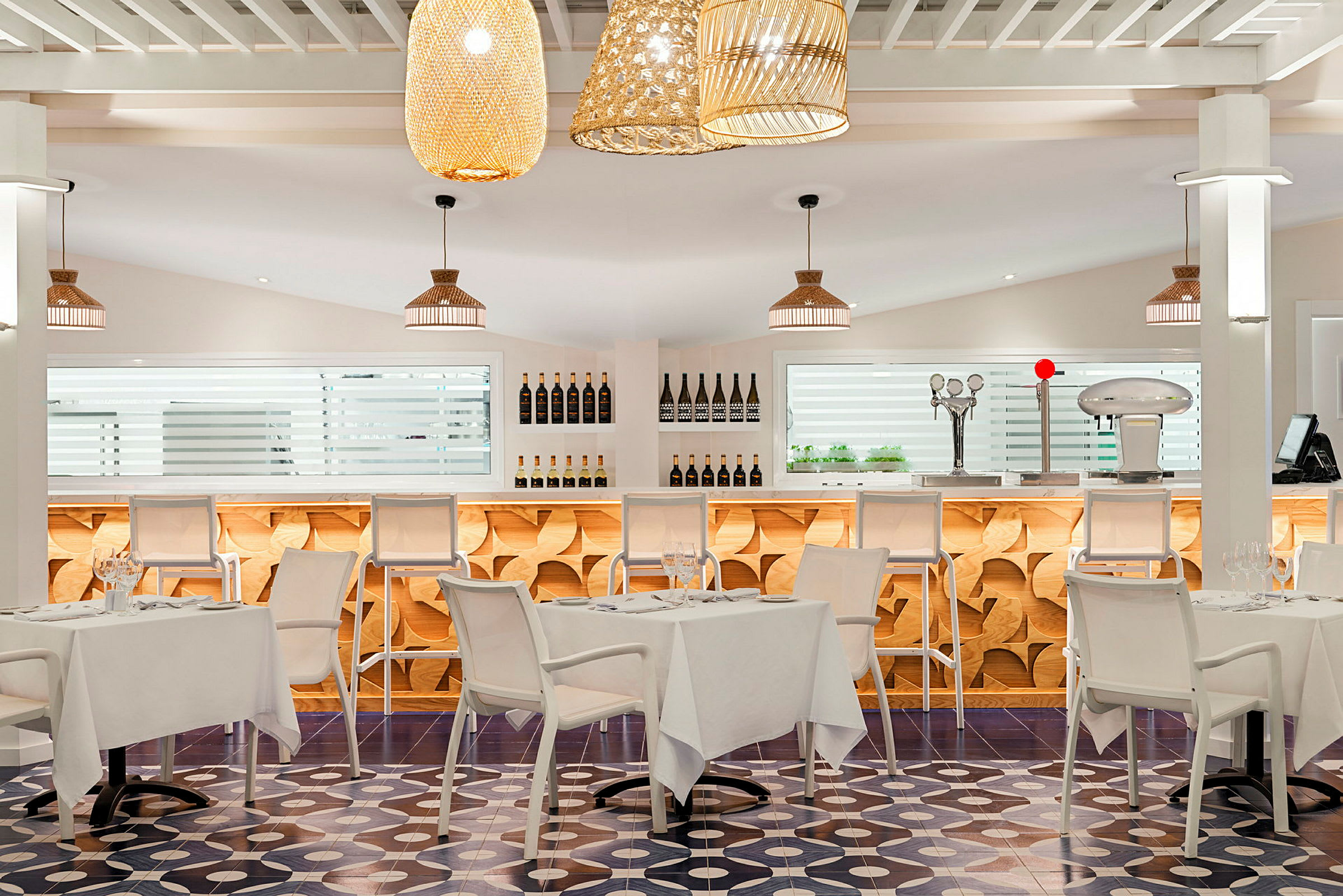 Moderne indrettet restaurant med lyse farver, stilfulde borde og stole samt bar i baggrunden. (AI-genereret tekst)