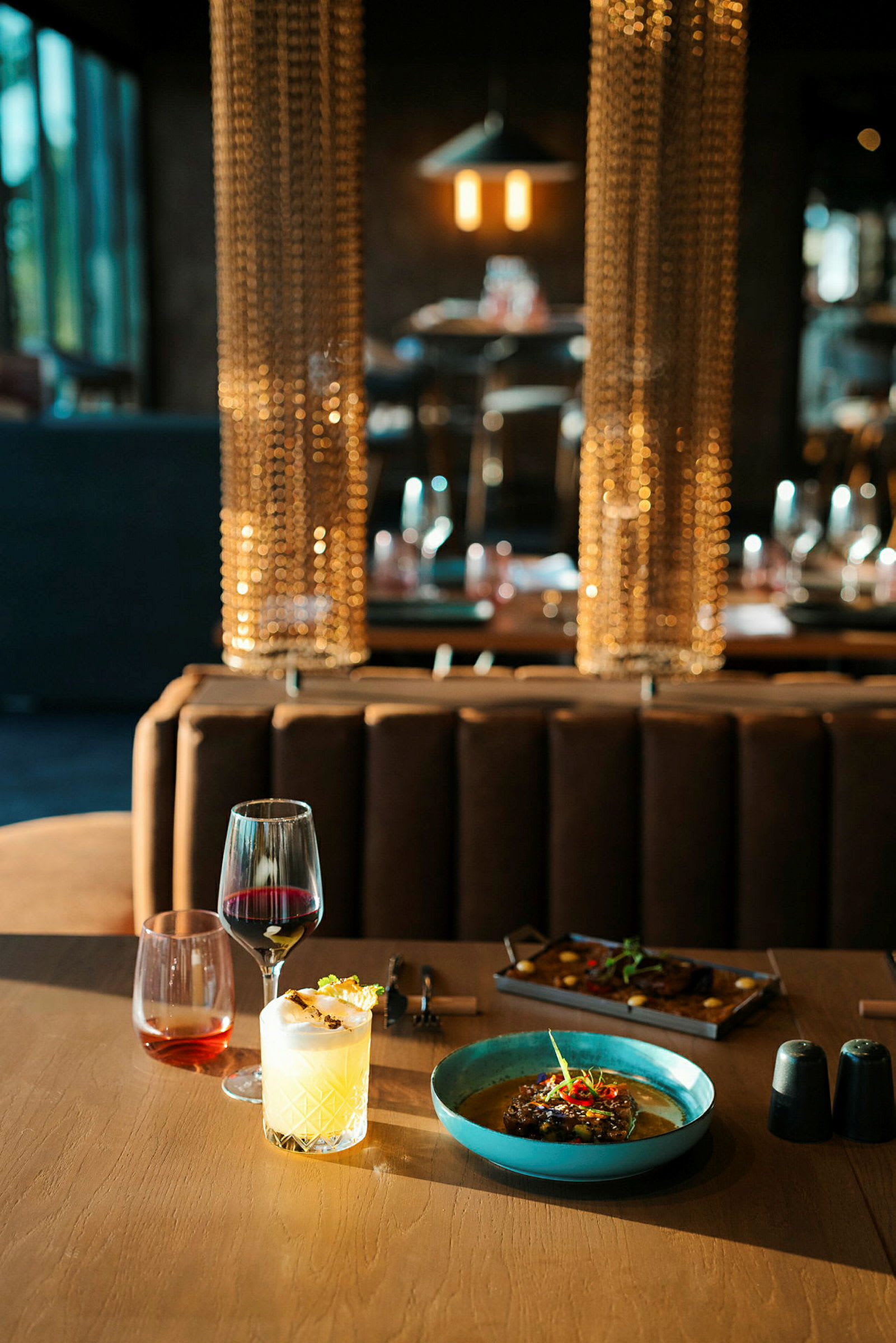 Et dækket bord med mad og drikke i en restaurantmiljø. (AI-genereret tekst)